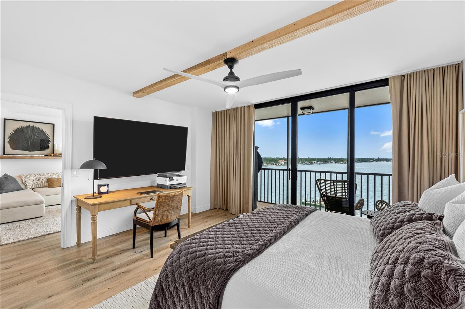 Second bedroom configured as a guest room and home-office setup with a private balcony, bay view, and motorized blinds. - 7100 SUNSHINE SKYWAY LN S #701, ST PETERSBURG