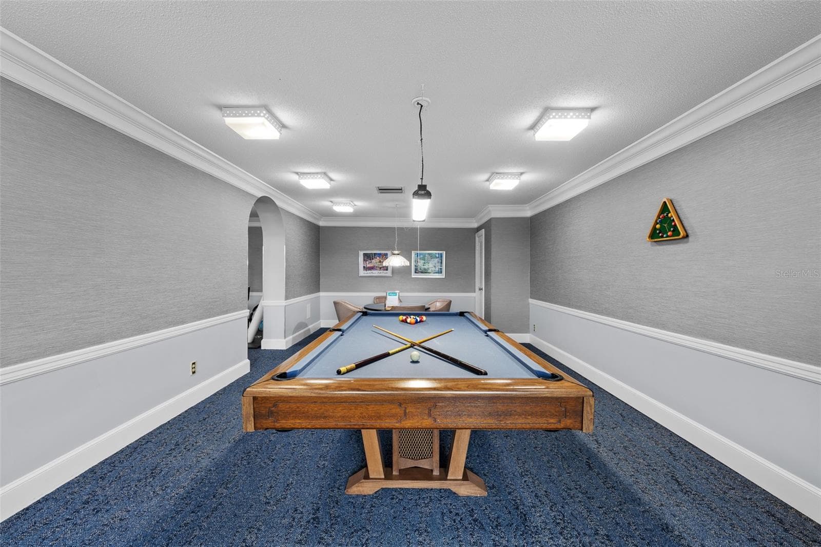 Community game room with a regulation billiards table, lounge seating, and arched architectural details. - 7100 SUNSHINE SKYWAY LN S #701, ST PETERSBURG