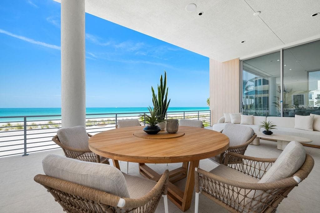 Main floor terrace highlights 40 feet of outdoor living space featuring Longboard™ accents to compliment to azure blue Gulf - 6489 GULFSIDE RD, LONGBOAT KEY