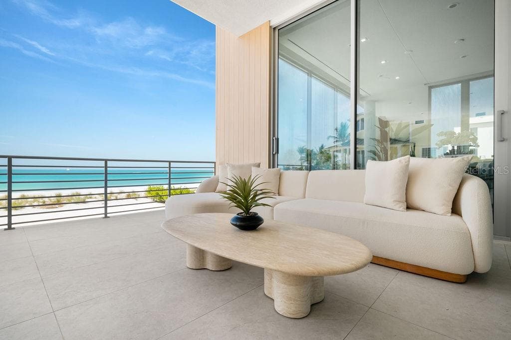 Main floor terrace highlights 40 feet of outdoor living space featuring Longboard™ accents to compliment to azure blue Gulf - 6489 GULFSIDE RD, LONGBOAT KEY