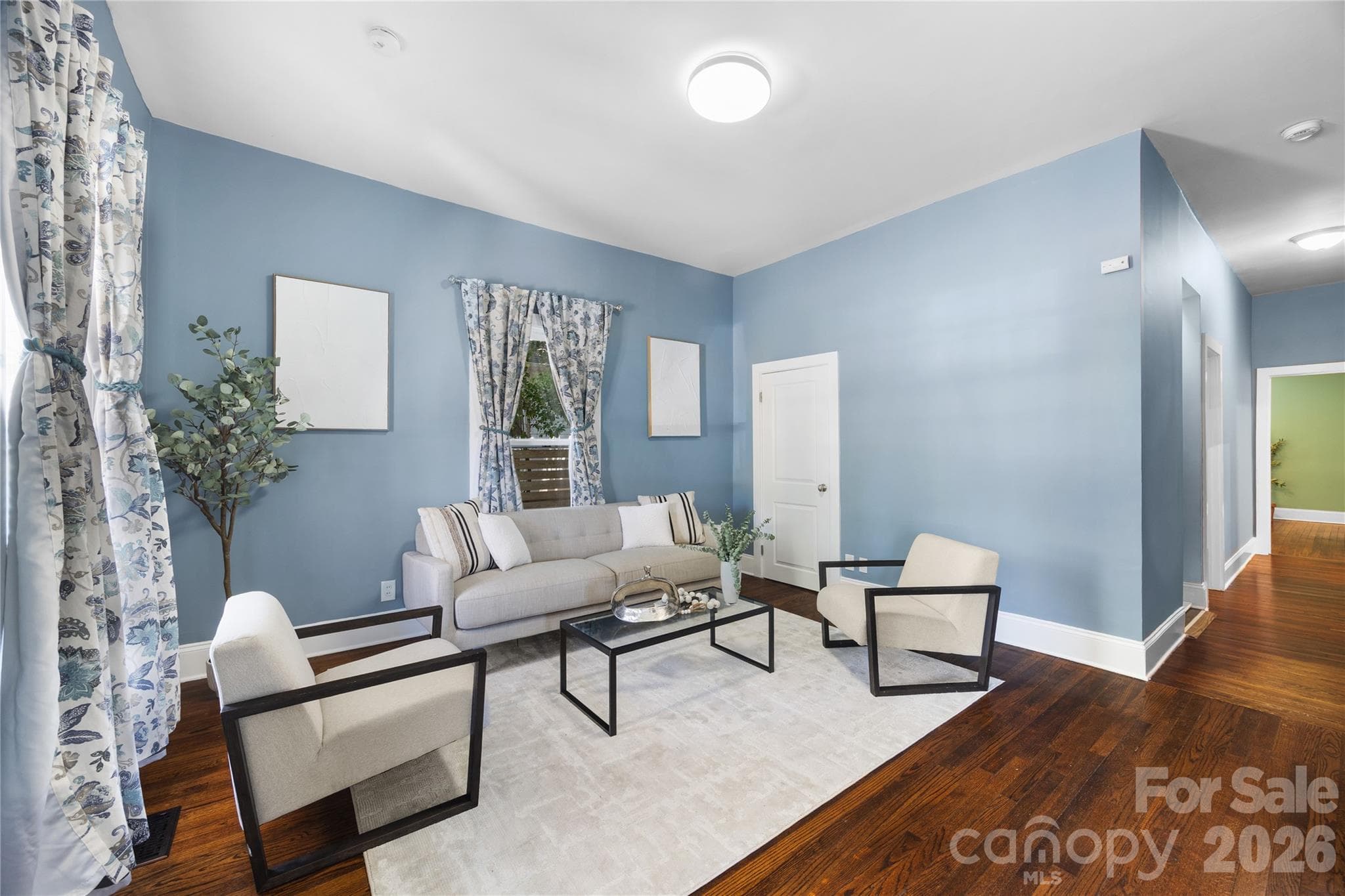 Timeless character meets modern style in this inviting living room featuring soaring ceilings and classic hardwood floors. - Charlotte