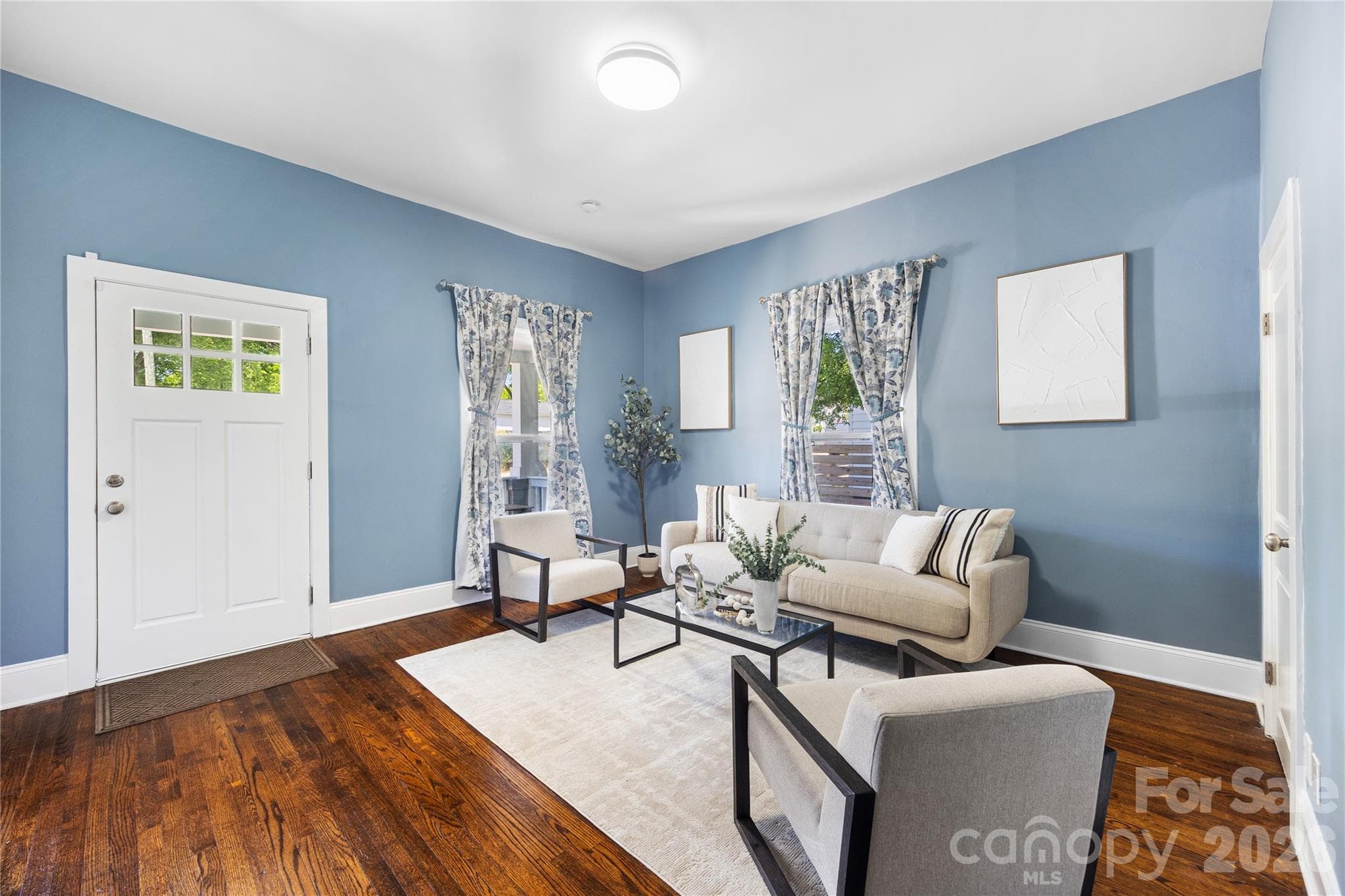Stylish living room designed with a perfect mix of historic charm, elevated ceilings, and contemporary touches. - Charlotte