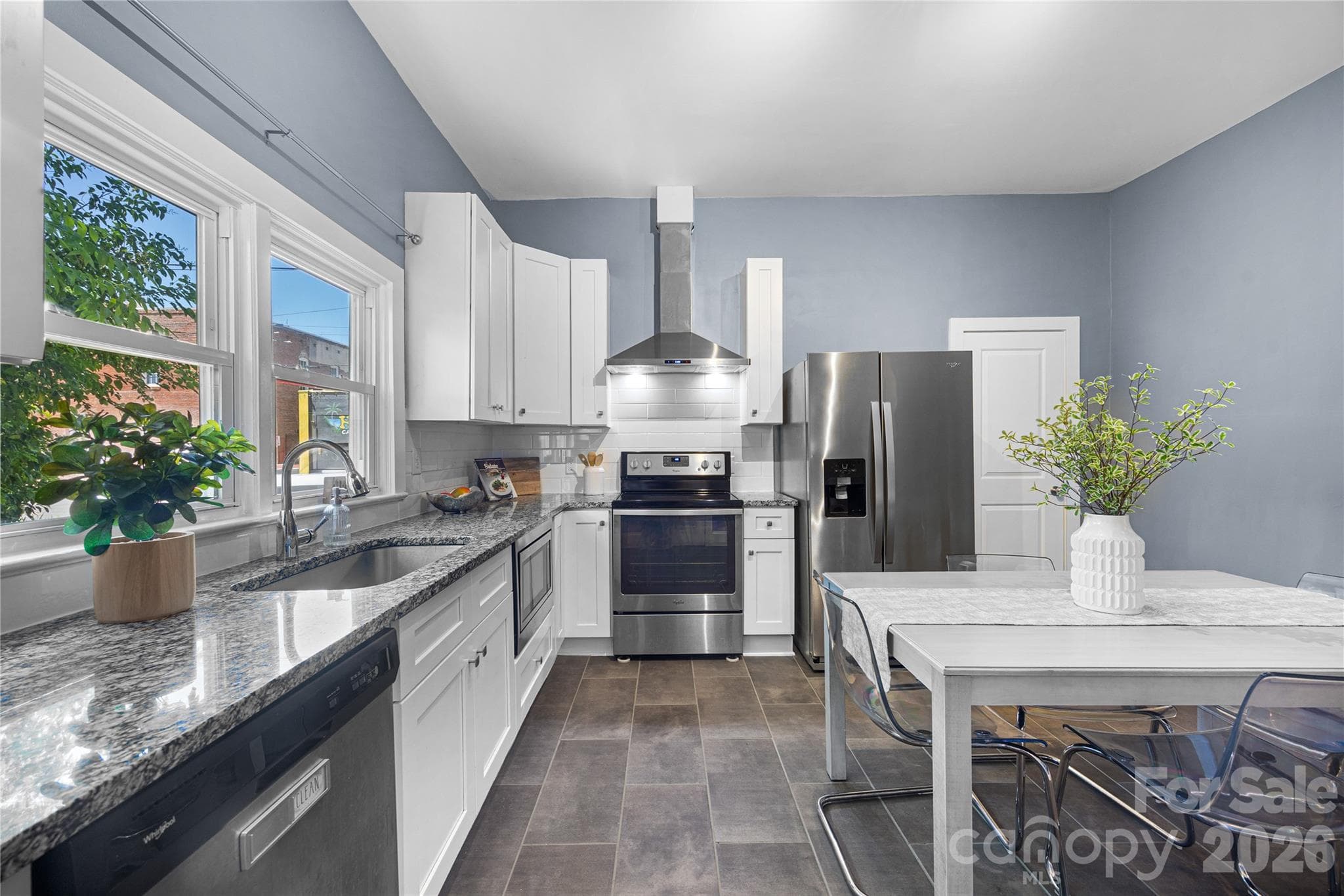 Fresh and functional kitchen featuring updated granite countertops, stainless steel appliances, and bright open space. - Charlotte