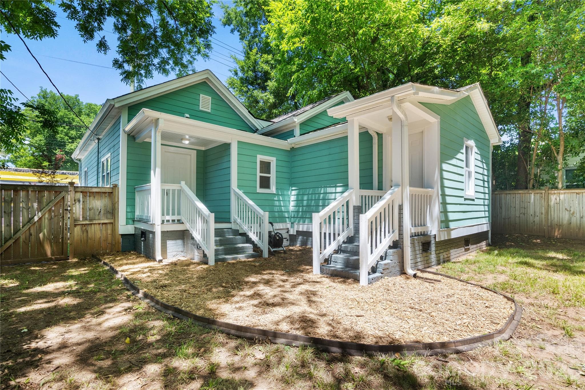 The back of the home offers to separate entrances and covered porches. - Charlotte