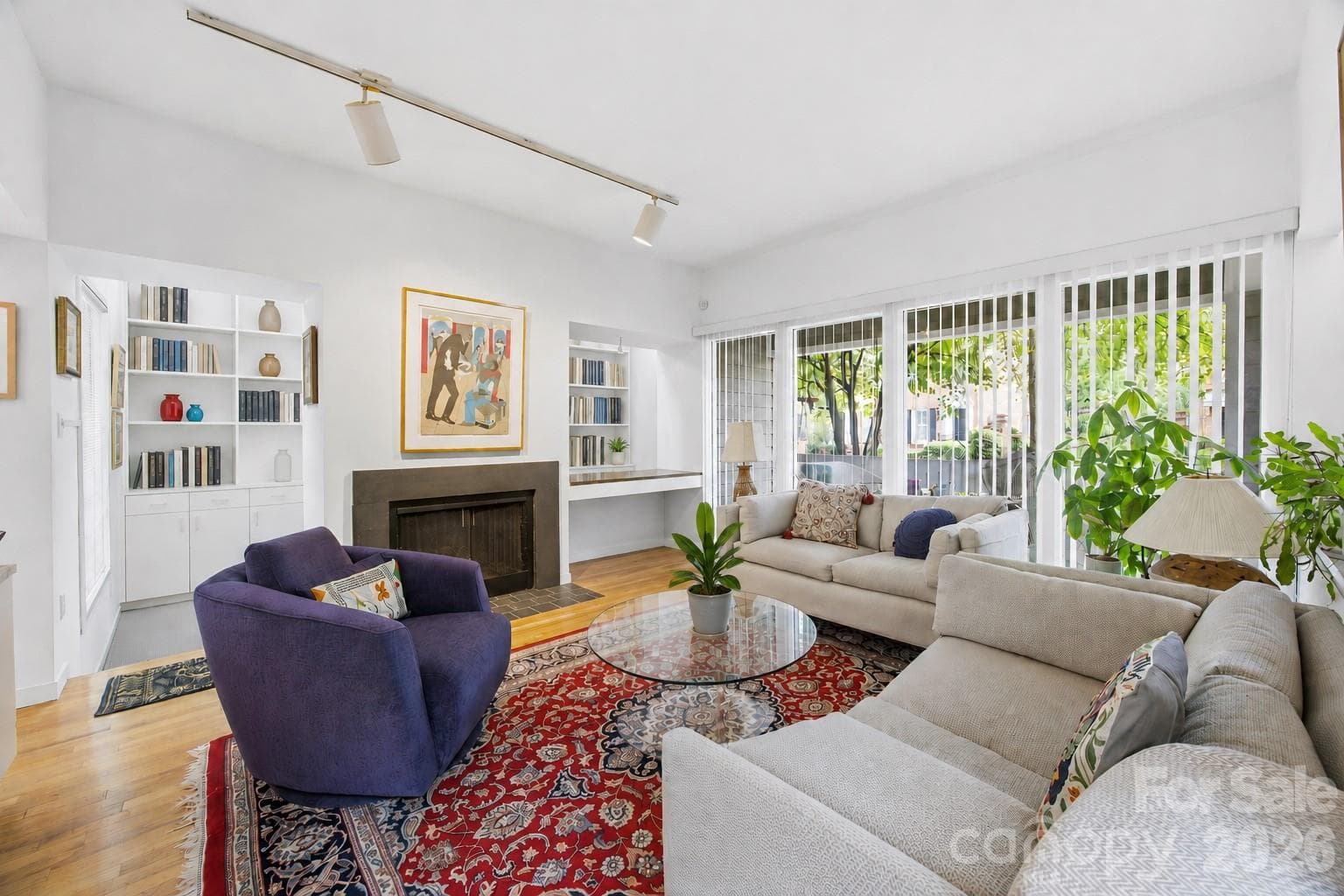 Warm and inviting main living space featuring hardwood floors, built-ins, gas fireplace, and abundant natural light. - Charlotte