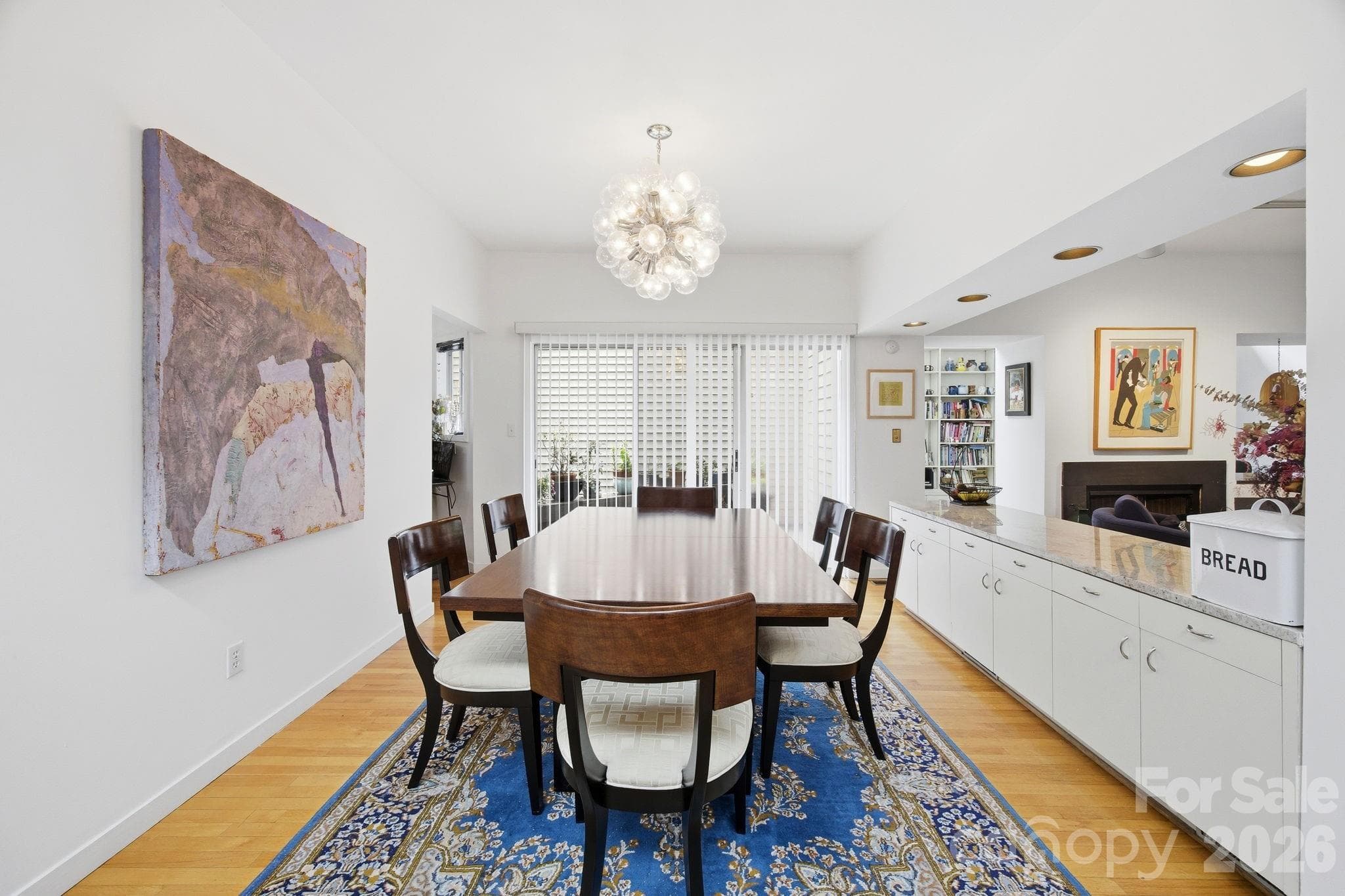 Alternate view of the elegant formal dining space featuring contemporary lighting, hardwood floors, and seamless flow into the surrounding living and entertaining areas. - Charlotte