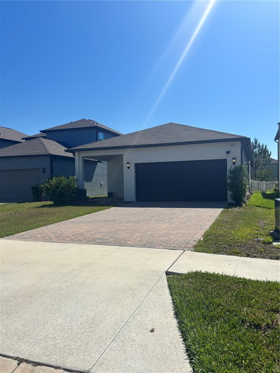 Back of the home with a 2 car garage. - 9601 FLOURISH DR, LAND O LAKES
