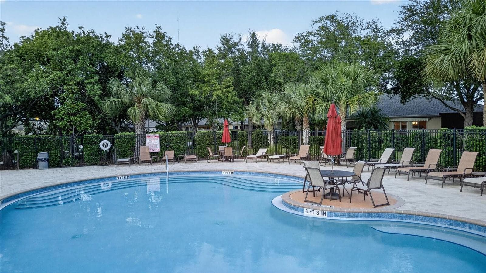Community pool and surrounding lounge area for relaxing outdoors. - 2153 BARRACUDA CT, HOLIDAY