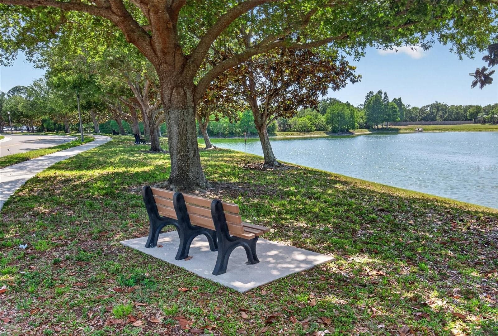 Community pond with shaded seating and peaceful outdoor surroundings. - 2153 BARRACUDA CT, HOLIDAY