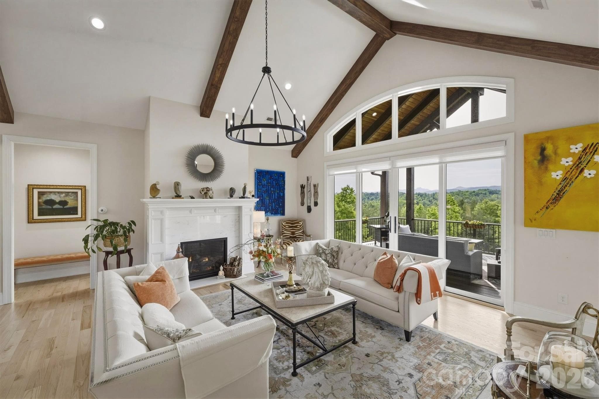 In the living room, cathedral ceilings, accented by walnut stained beams, lead your eyes to floor to ceiling windows and sliding glass doors that frame spellbinding views of Table Rock, Brown Mountain, and more.   A wide transom window crowns the space, bathing the interior in more soft, natural light. - Lenoir
