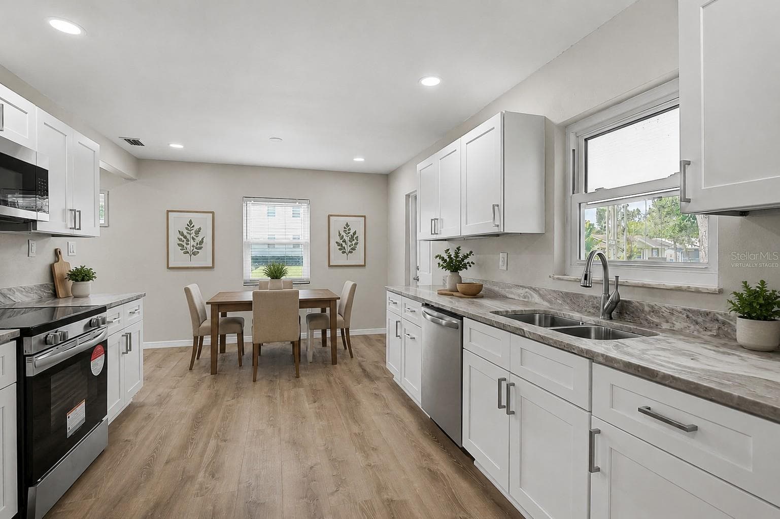 Eat In Kitchen and Door Leading to Carport Virtually Staged - 102 20TH ST NE, BRADENTON