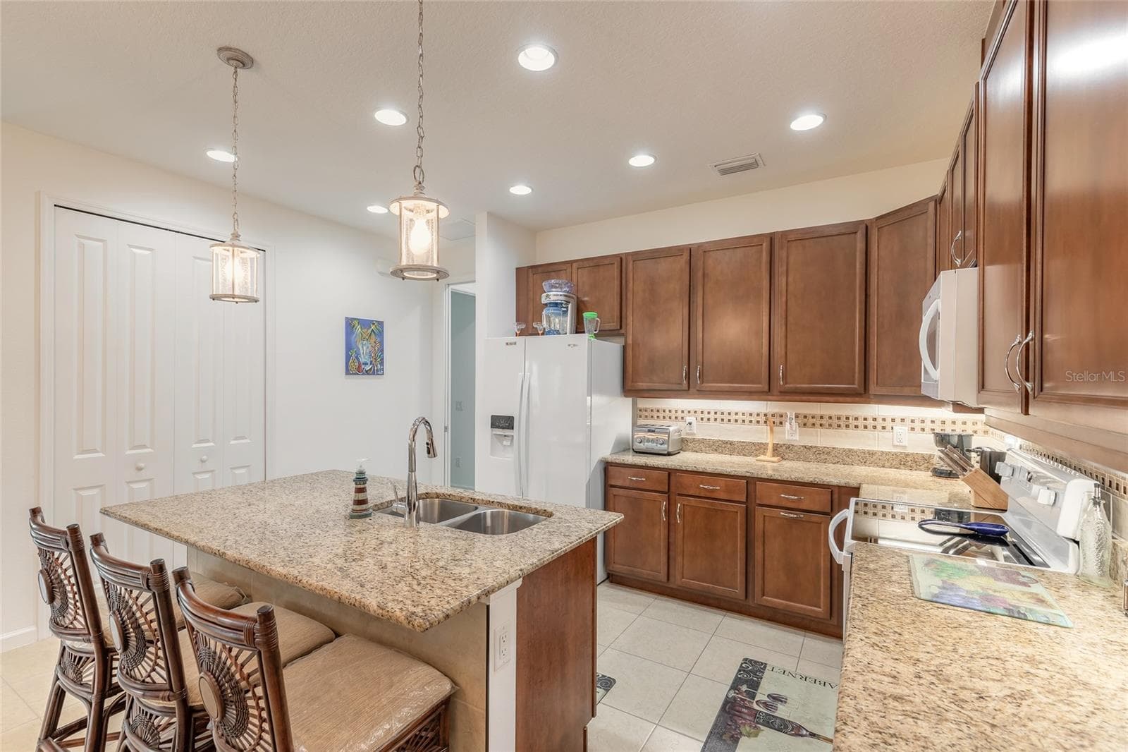 Kitchen island with bar seating & tile kick plate - 230 SAND BAR LN, DAYTONA BEACH