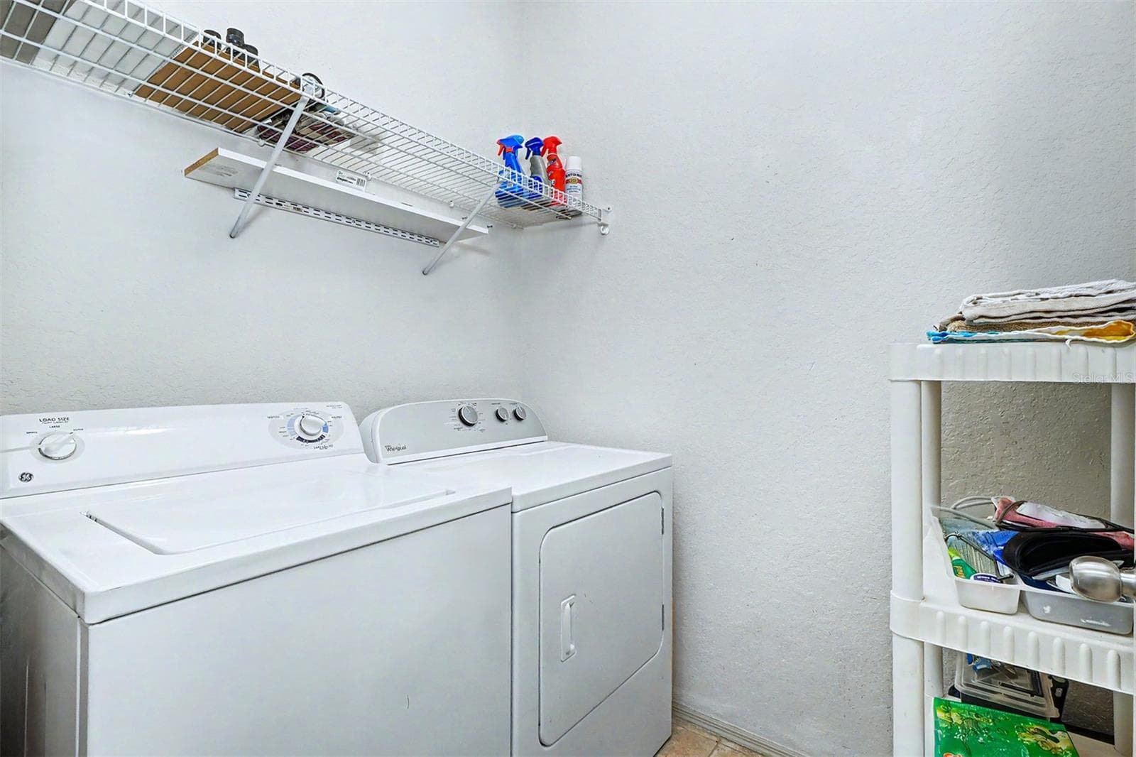 Laundry room with full size washer and dryer and storage shelf - 2746 VIA TIVOLI #110B, CLEARWATER