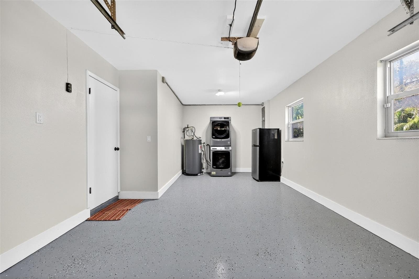 Single garage with garage door opened. Fresh epoxy flooring. Garage stacked washer and dryer. - 19801 GUNN HWY, ODESSA