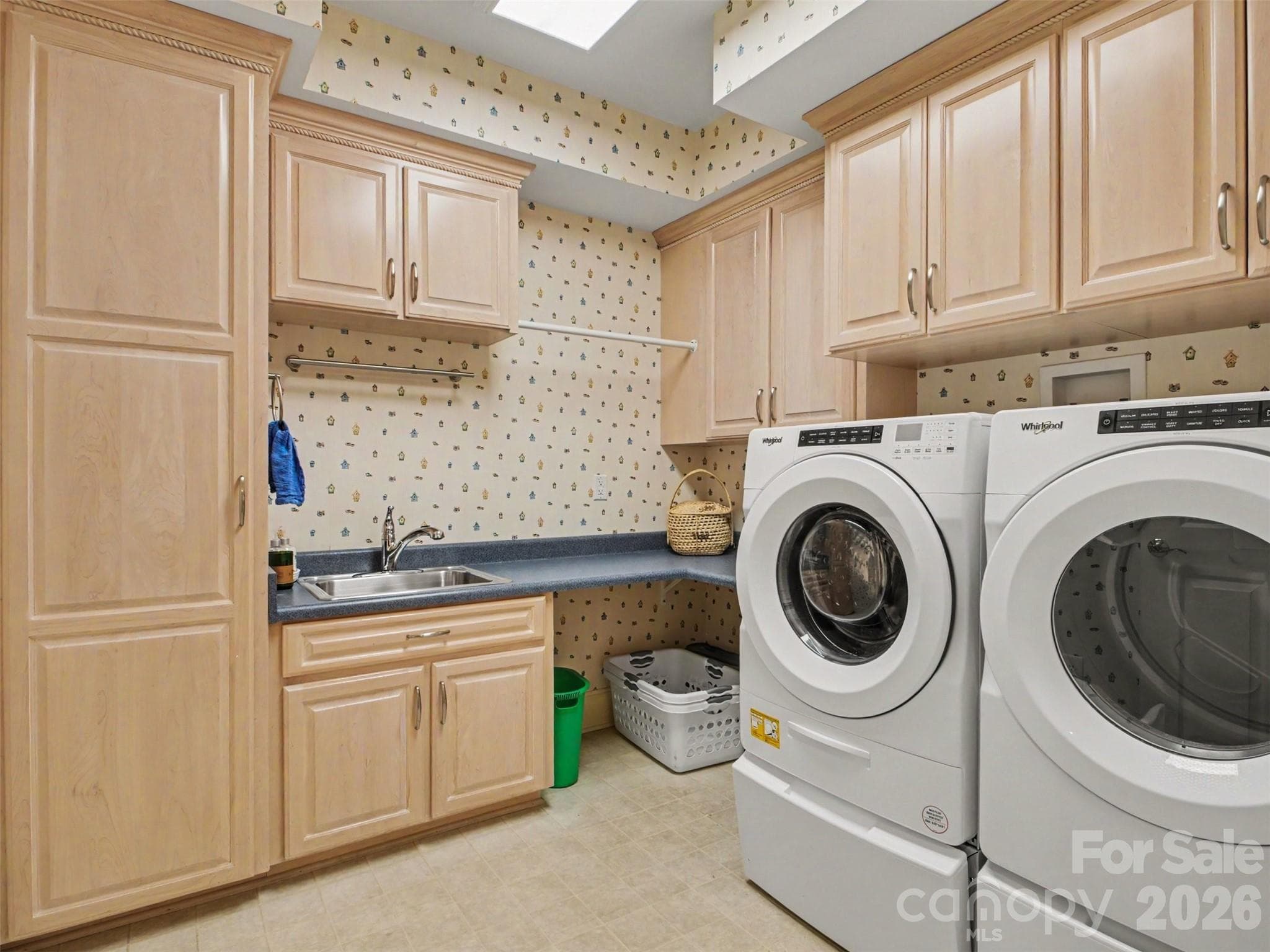 There is a conveniently located separate laundry room with a sink, folding/work space, hanging area, built-in ironing board, and plenty of storage! The washer and dryer convey. - 1422 Stone Gate Drive, Shelby