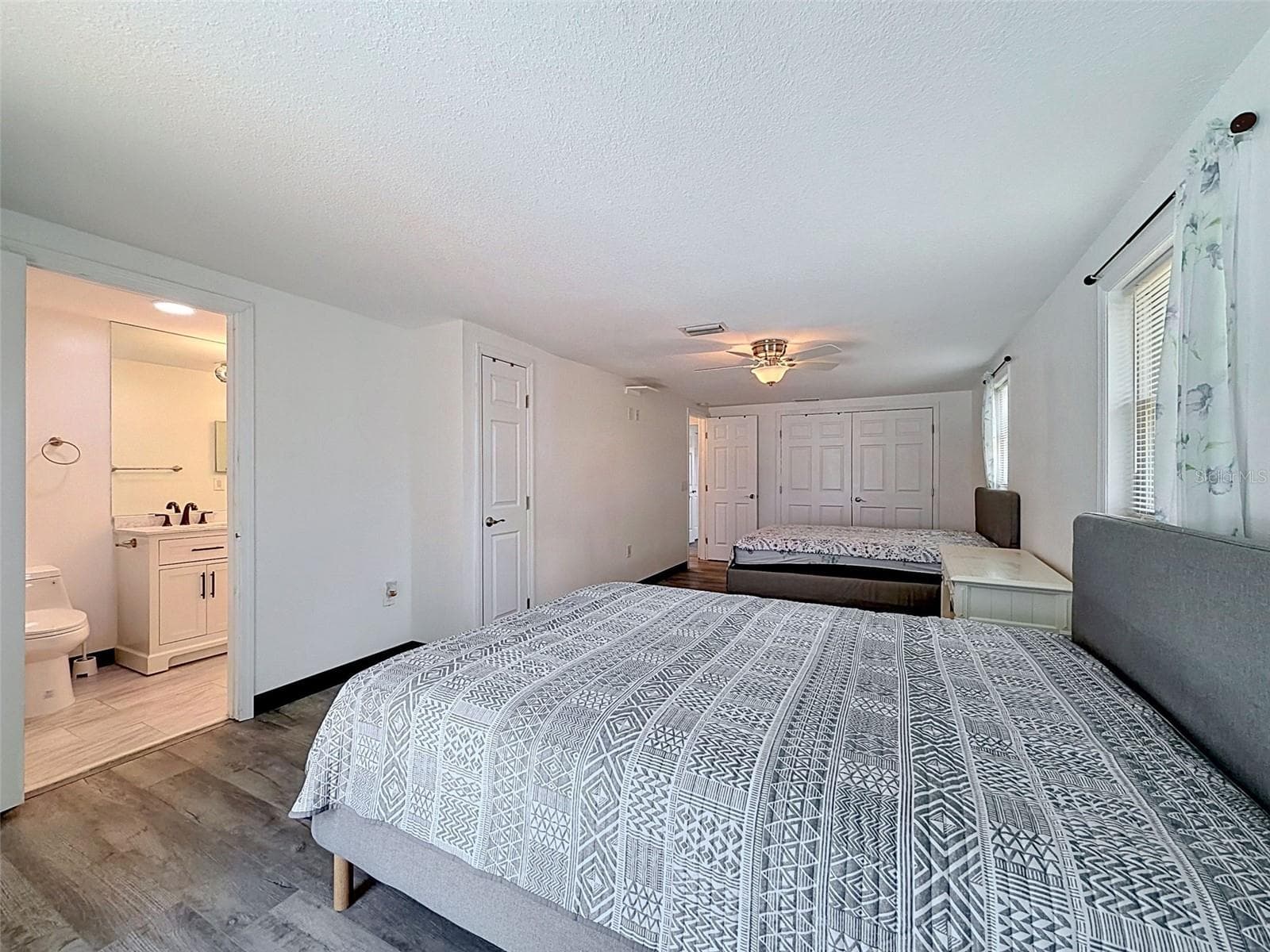 Large primary bedroom currently accommodates two queen beds. - 12735 1ST ISLE, HUDSON