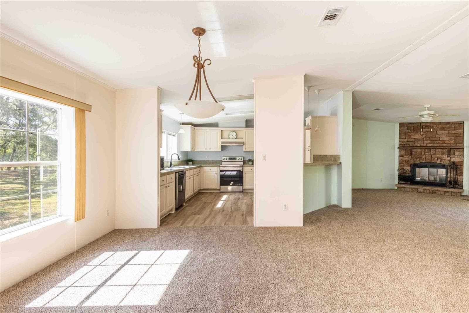 View of the dining area, kitchen and great room. - 14221 HURRICANE DR, WEEKI WACHEE
