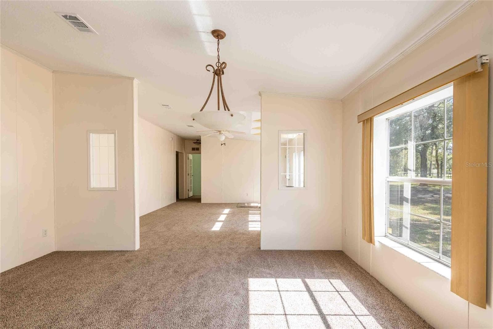 View from kitchen to dining room and living room. - 14221 HURRICANE DR, WEEKI WACHEE