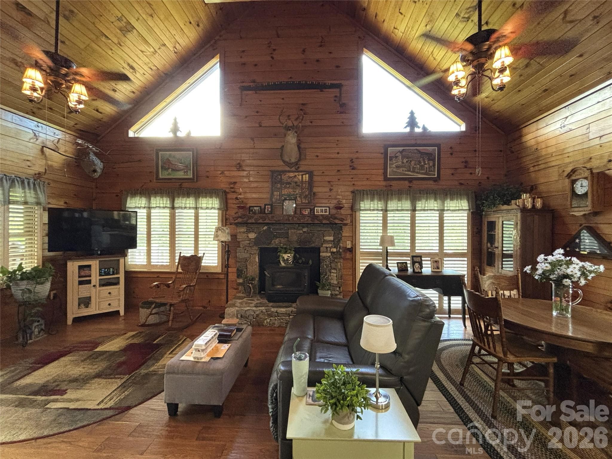 LIving area with a wood stove inserted in the fire place. Dining area. - Maggie Valley