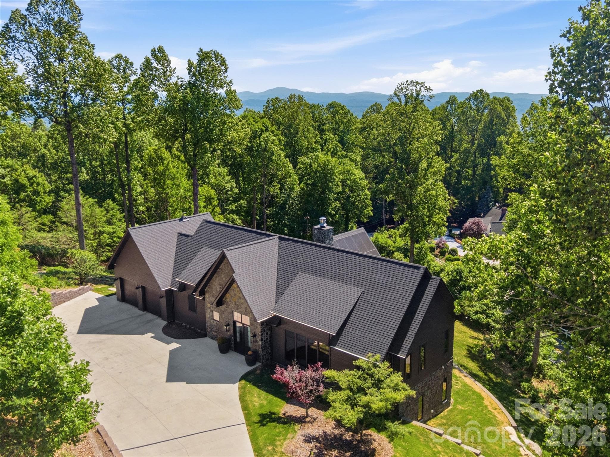 Front elevation showcasing stone accents, dramatic rooflines, and scenic surroundings. - 241 Tower Circle, Hendersonville