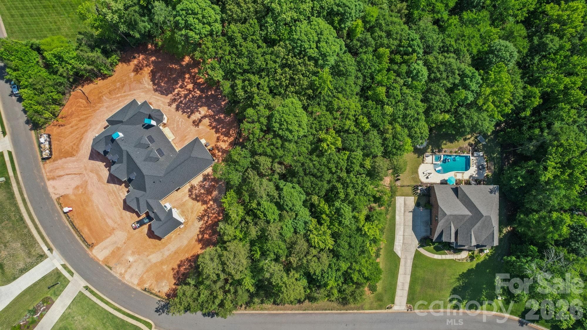 Property is the wooded area between the house under construction and the house with the pool. - Fort Mill