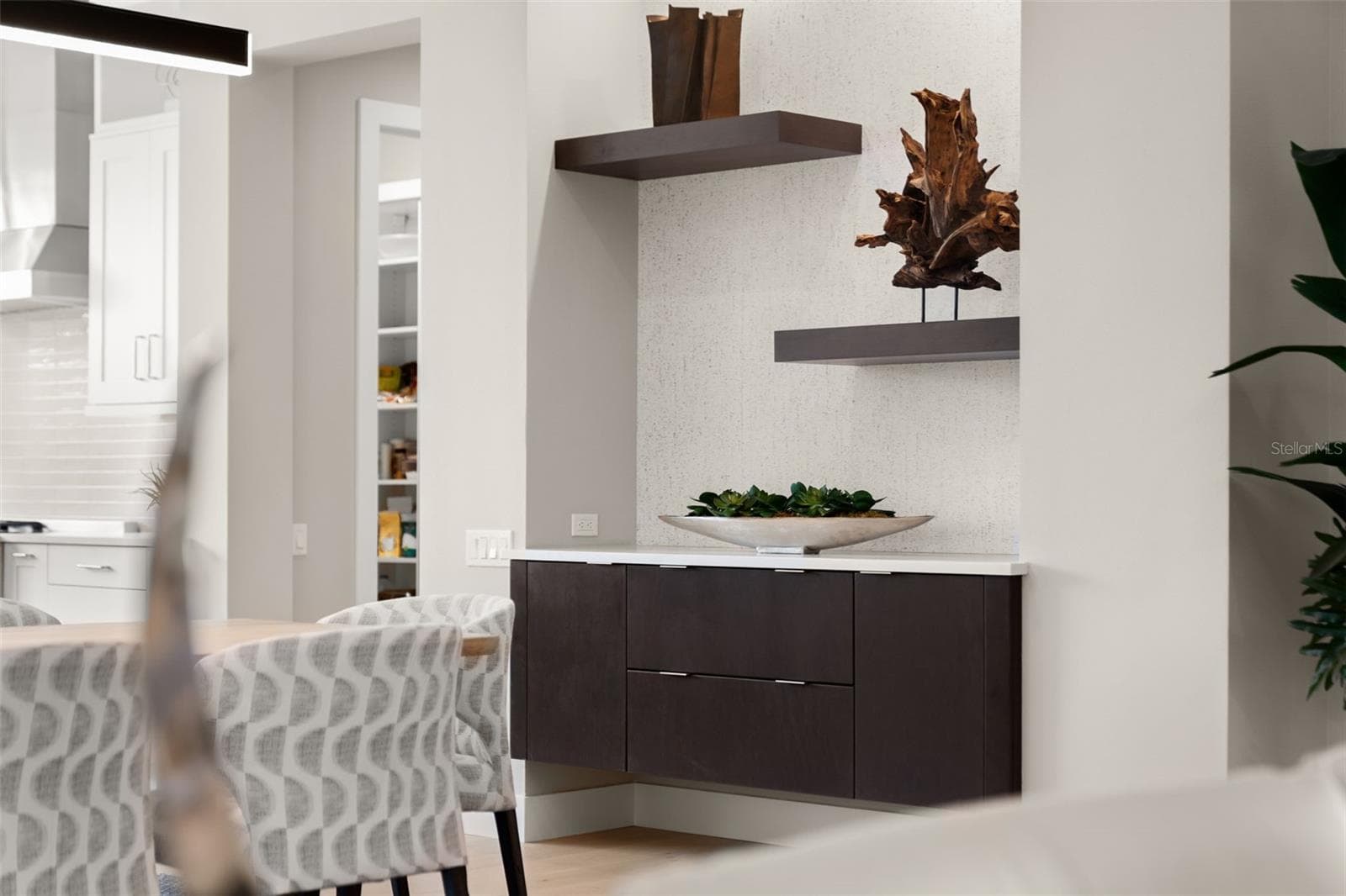 The dining room has a custom built-in buffet cabinetry with shelving, wallpaper accents, and recessed lighting. - 11721 RIVE ISLE RUN, PARRISH
