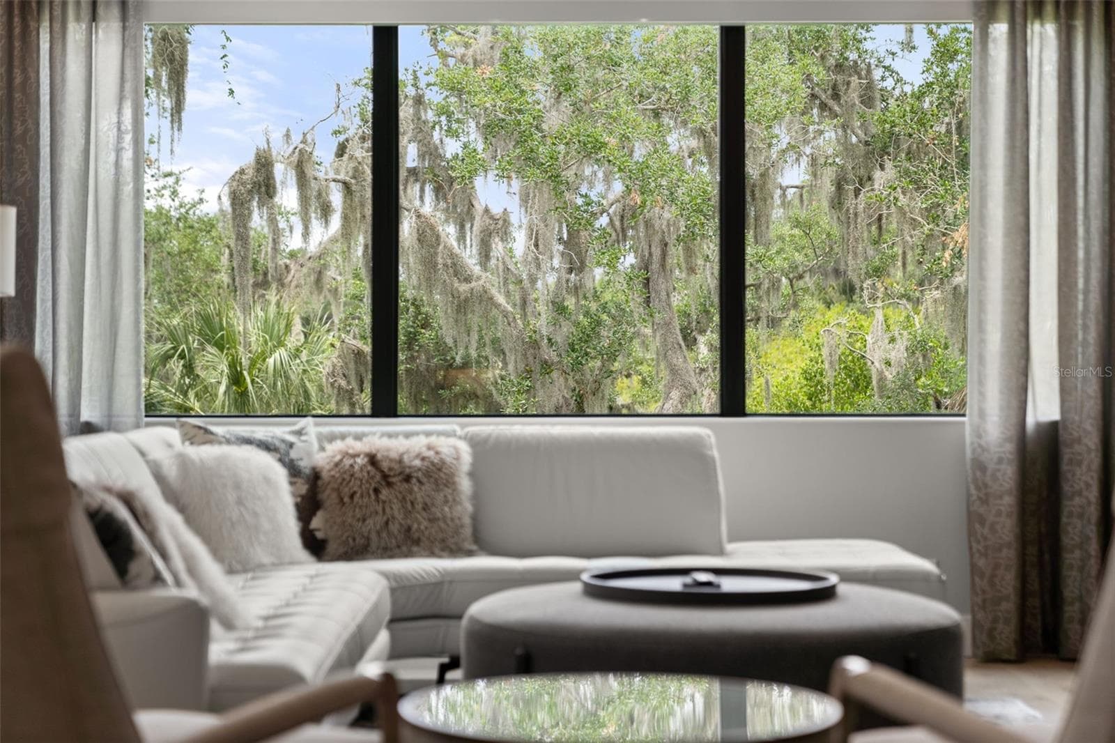 There is an electric shade and custom drapery on the oversized window in the bonus room. - 11721 RIVE ISLE RUN, PARRISH