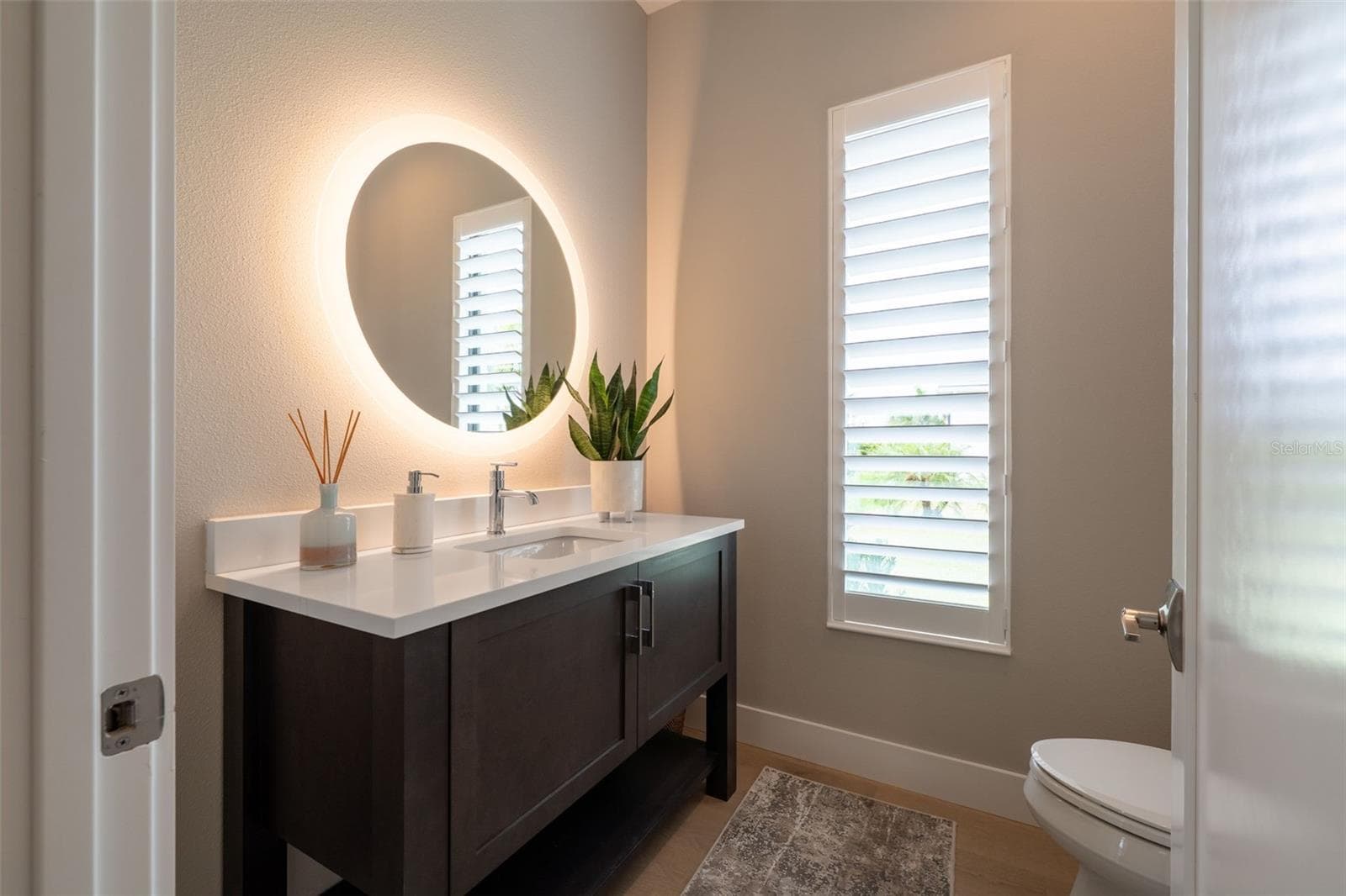 The half bathroom is beautifully designed with a backlit mirror and floating vanity. - 11721 RIVE ISLE RUN, PARRISH