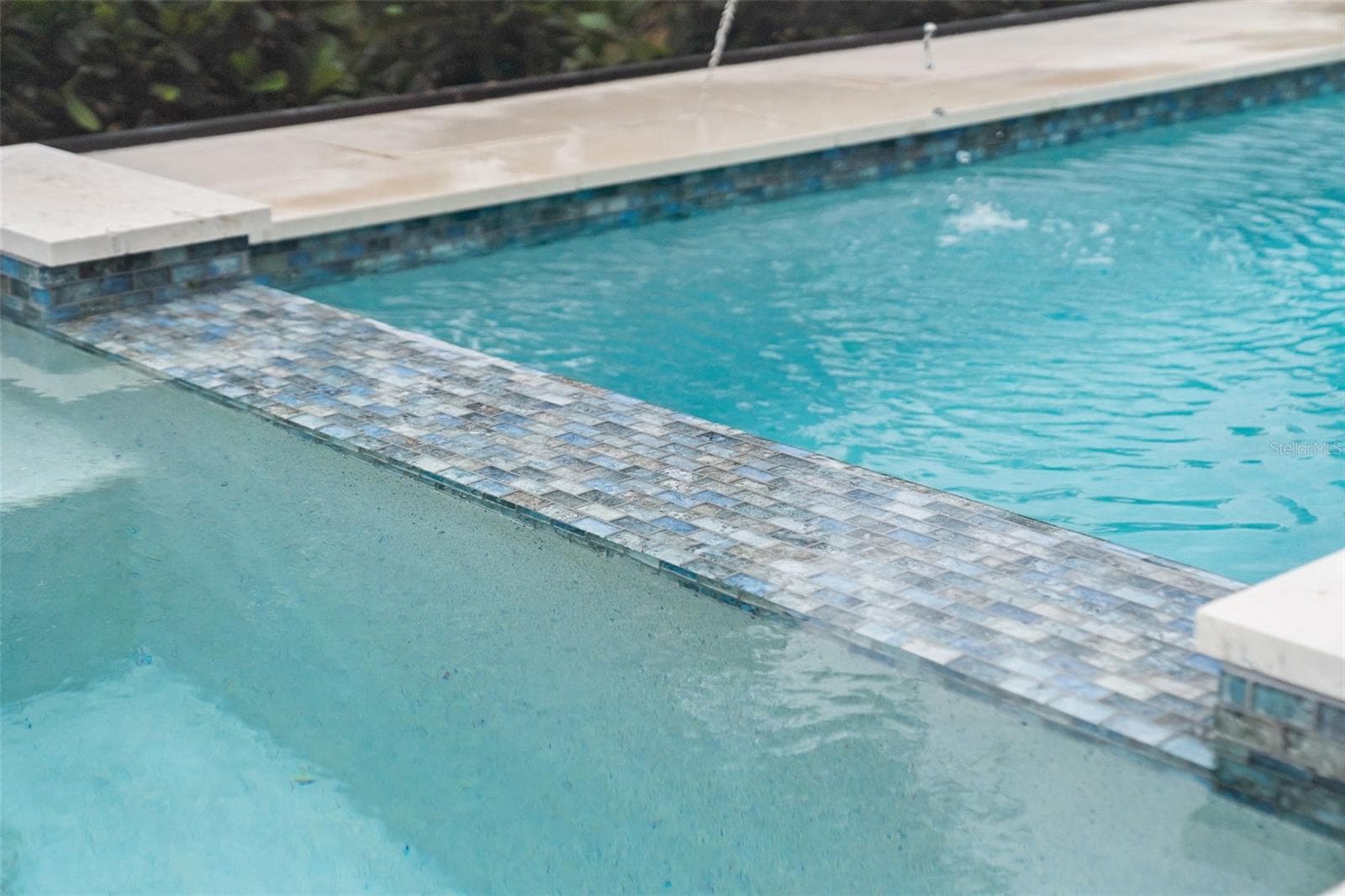 Custom tile and travertine flooring surround the saltwater pool. - 11721 RIVE ISLE RUN, PARRISH