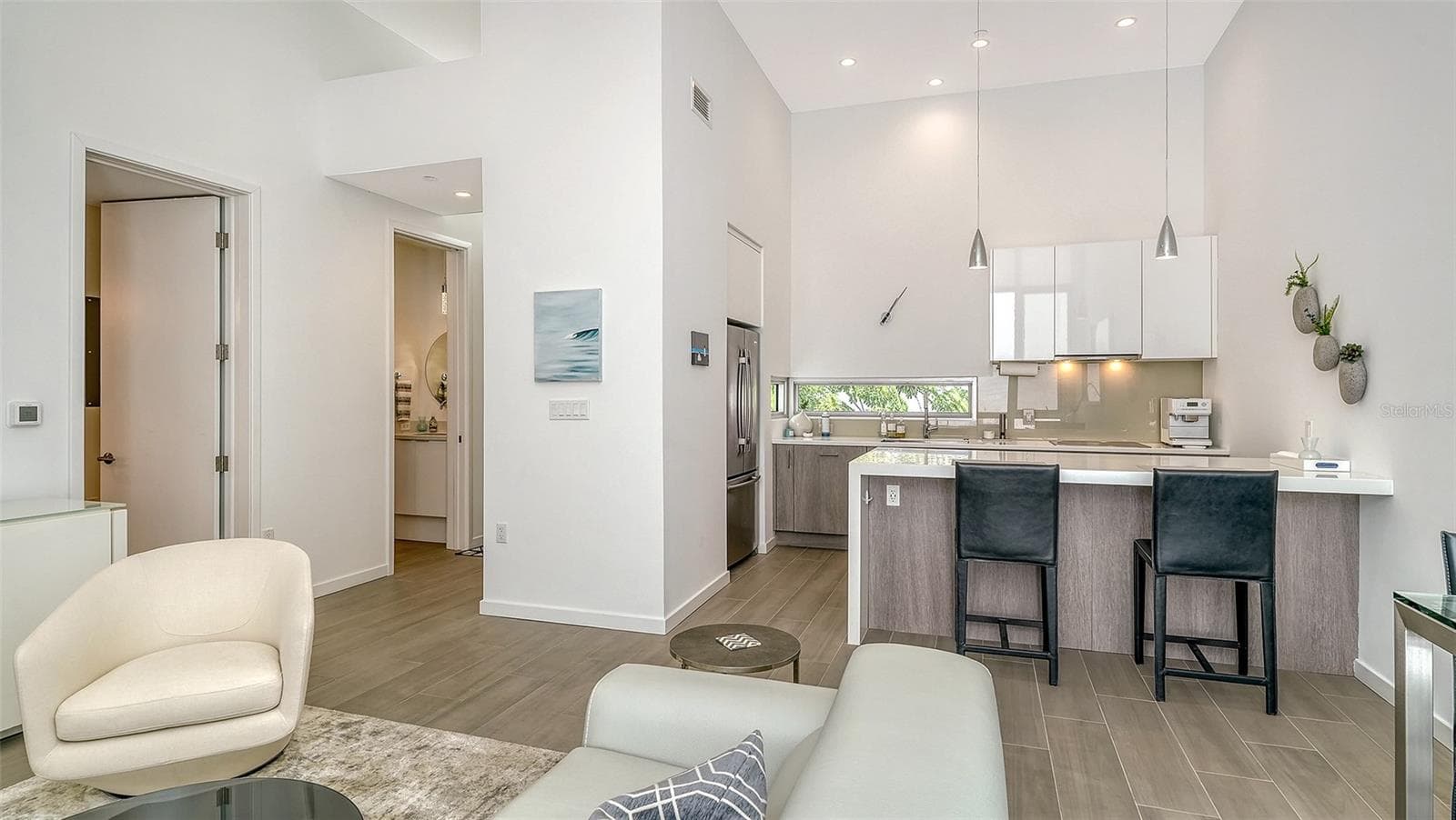 Spacious living room with dining area and seating at kitchen island. - 1350 5TH STREET #106, SARASOTA