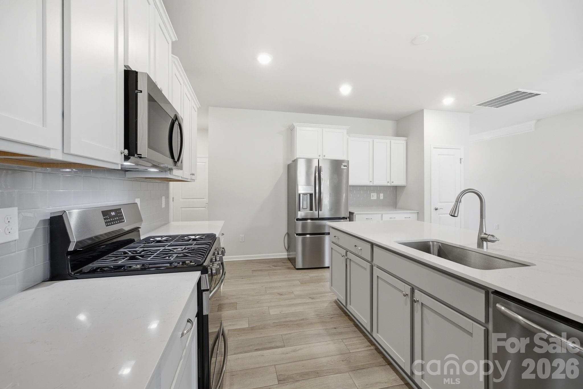 expansive quartz kitchen countertops and a sik in the island - Statesville