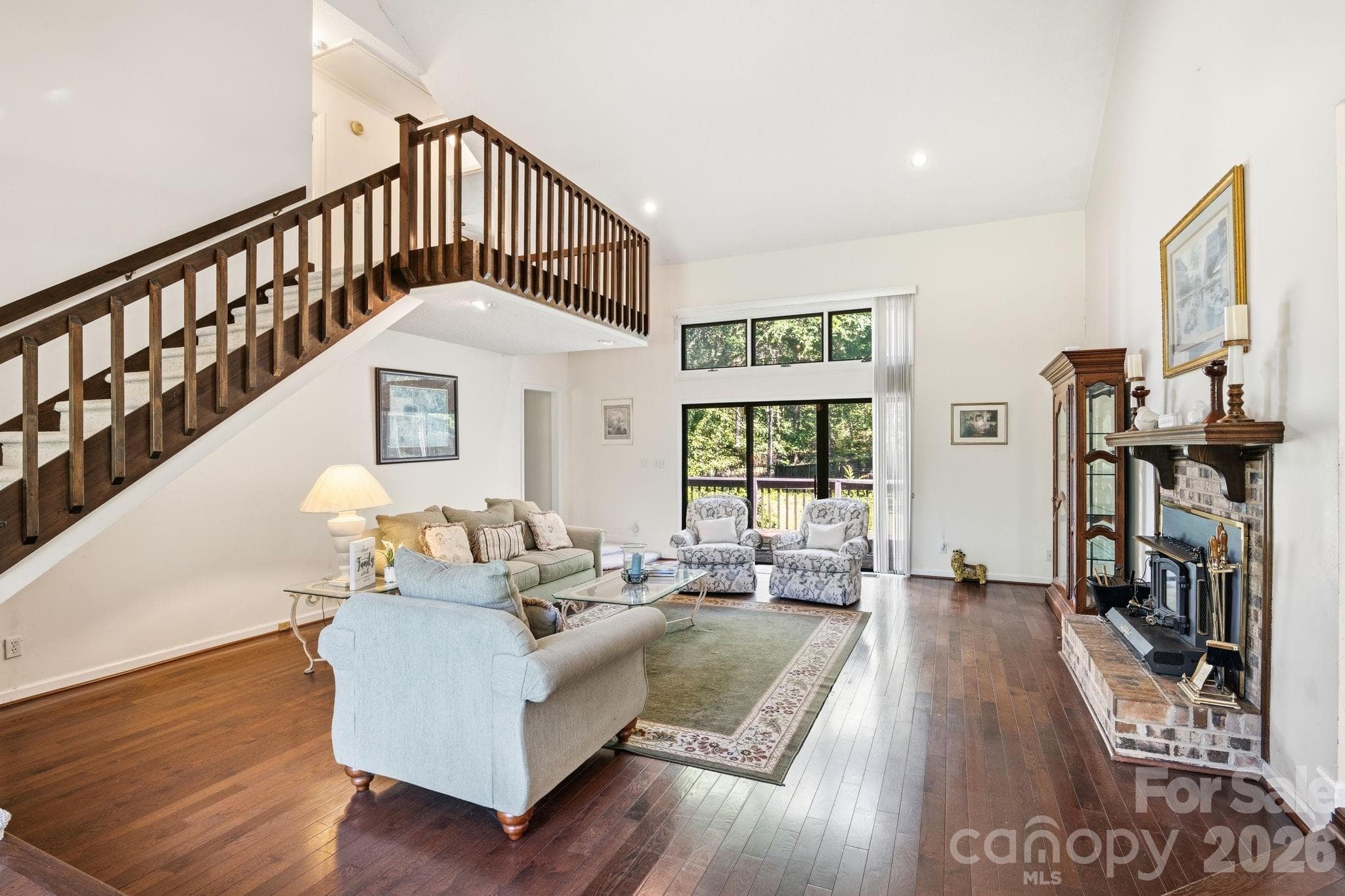 Beautiful great room with warmth and character as you enter the home. Cathedral ceilings, wood-burning fireplace with matching hearth, hardwood floors, and matching staircase railing. - 1775 Apple Tree Lane, Fort Mill