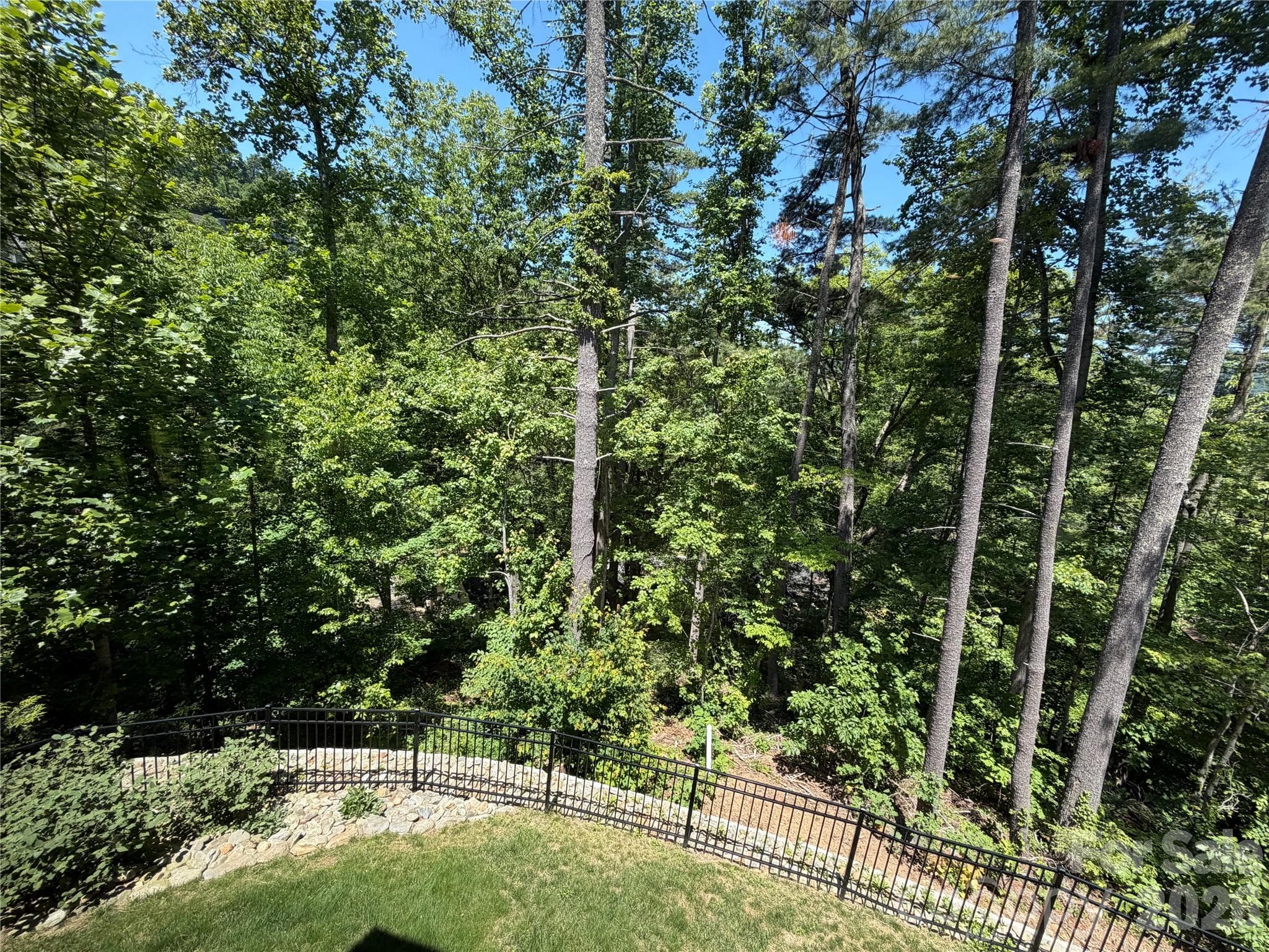 Located in an extremely private and quiet enclave towards the back of this beautiful development, this home is situated on a lot surrounded by nature. Enjoy the lush and fully fenced rear yard with seasonal mountain views! Neighbor has offered permanent easement for use of property below (beyond the white pipe seen on the back side of the fence) - can be used to expand the backyard for more entertaining area, gardening beds, or even a gorgeous swimming pool!! Ask agent for additional details. - Asheville