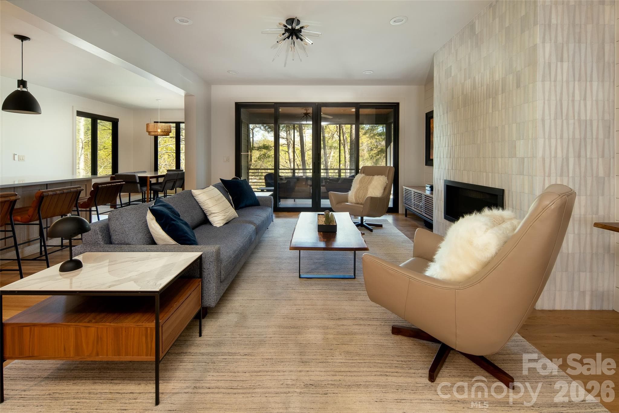 Uninterrupted sight-lines through the main living space out to the covered/screened porch and lush views. - Asheville
