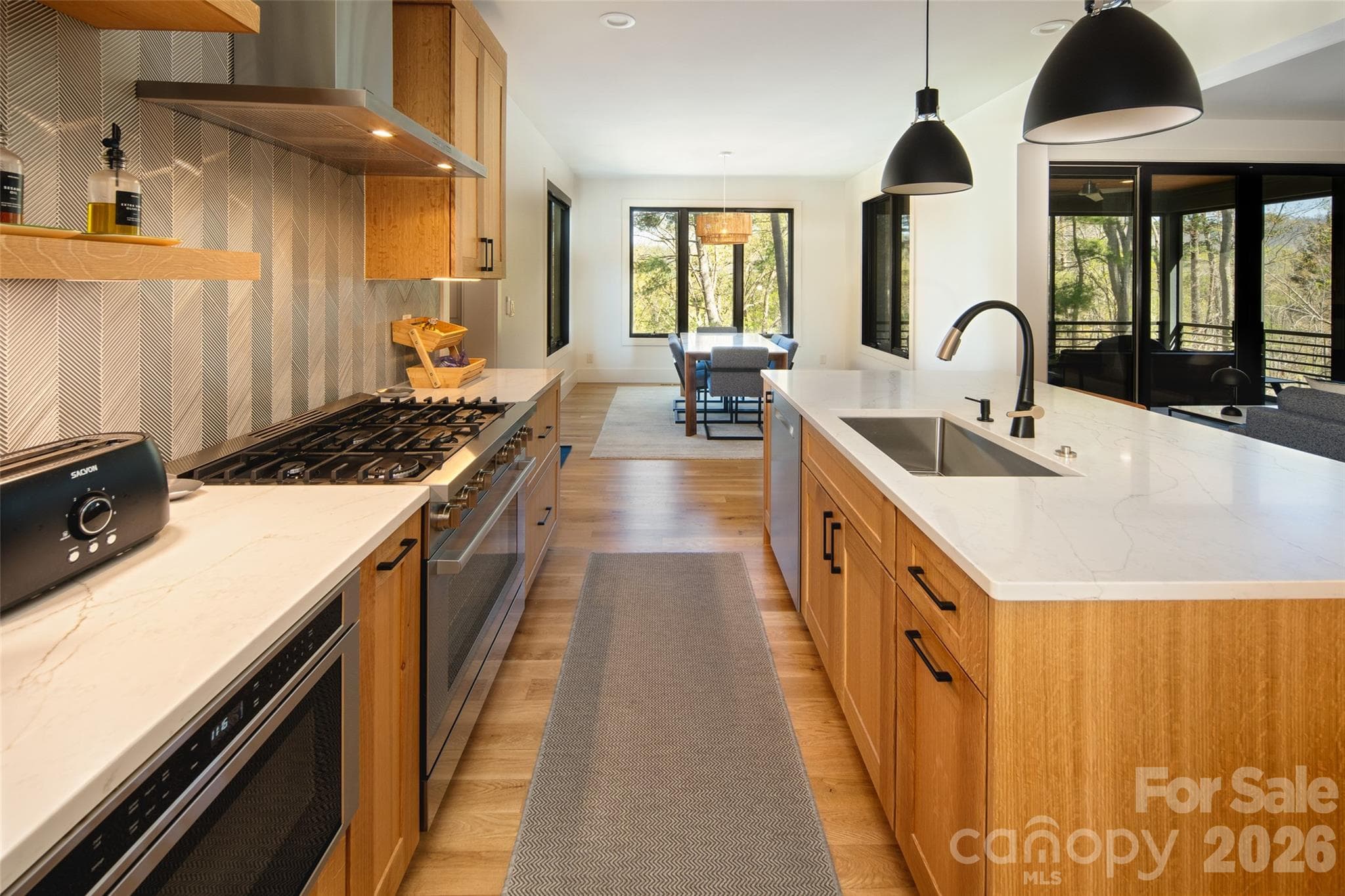 Large kitchen opens to spacious dining room/area with walls of windows bringing in light and gorgeous views. - Asheville