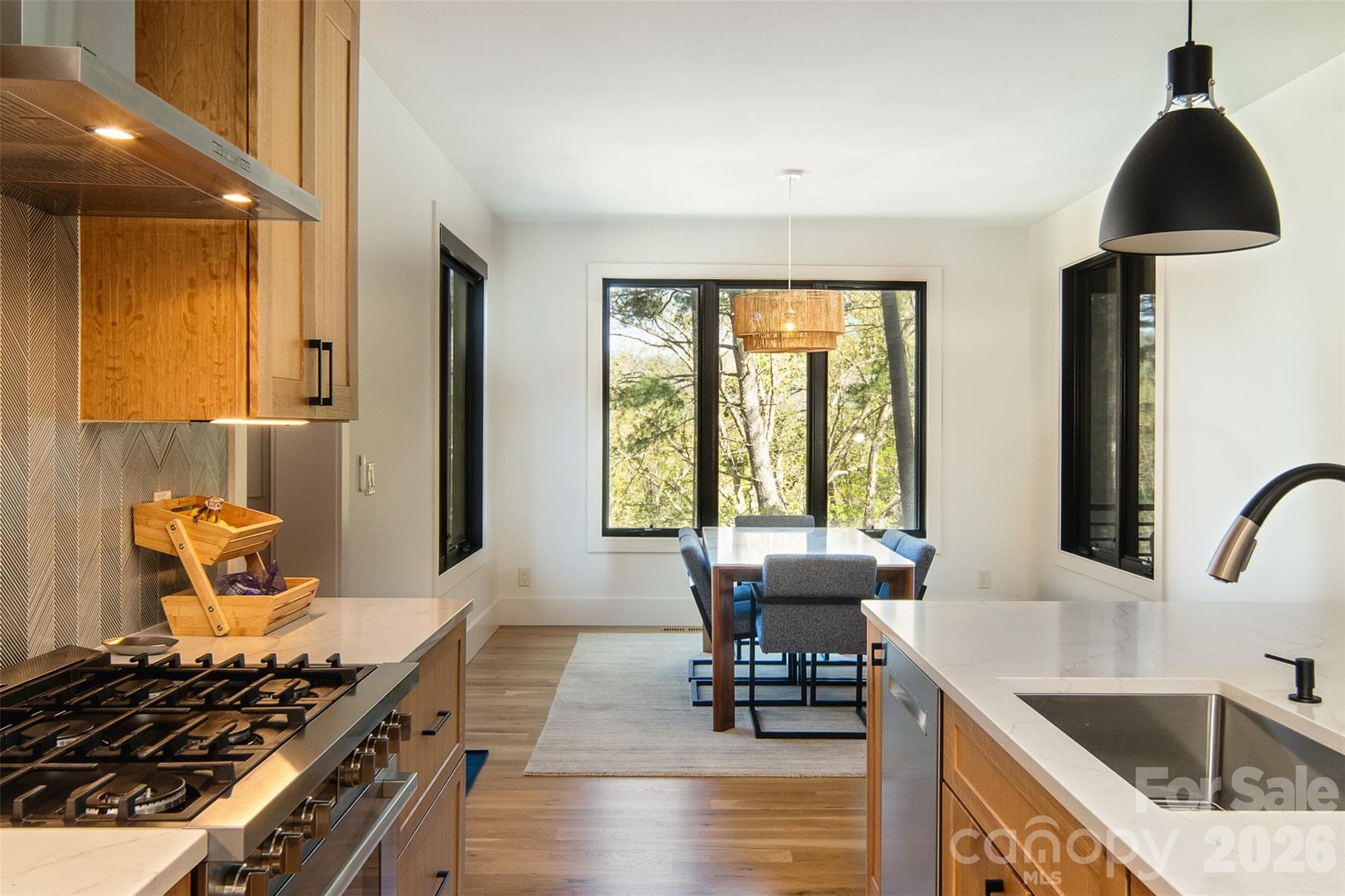 Light streams through the expansive windows on all three walls of the spacious dining room. - Asheville