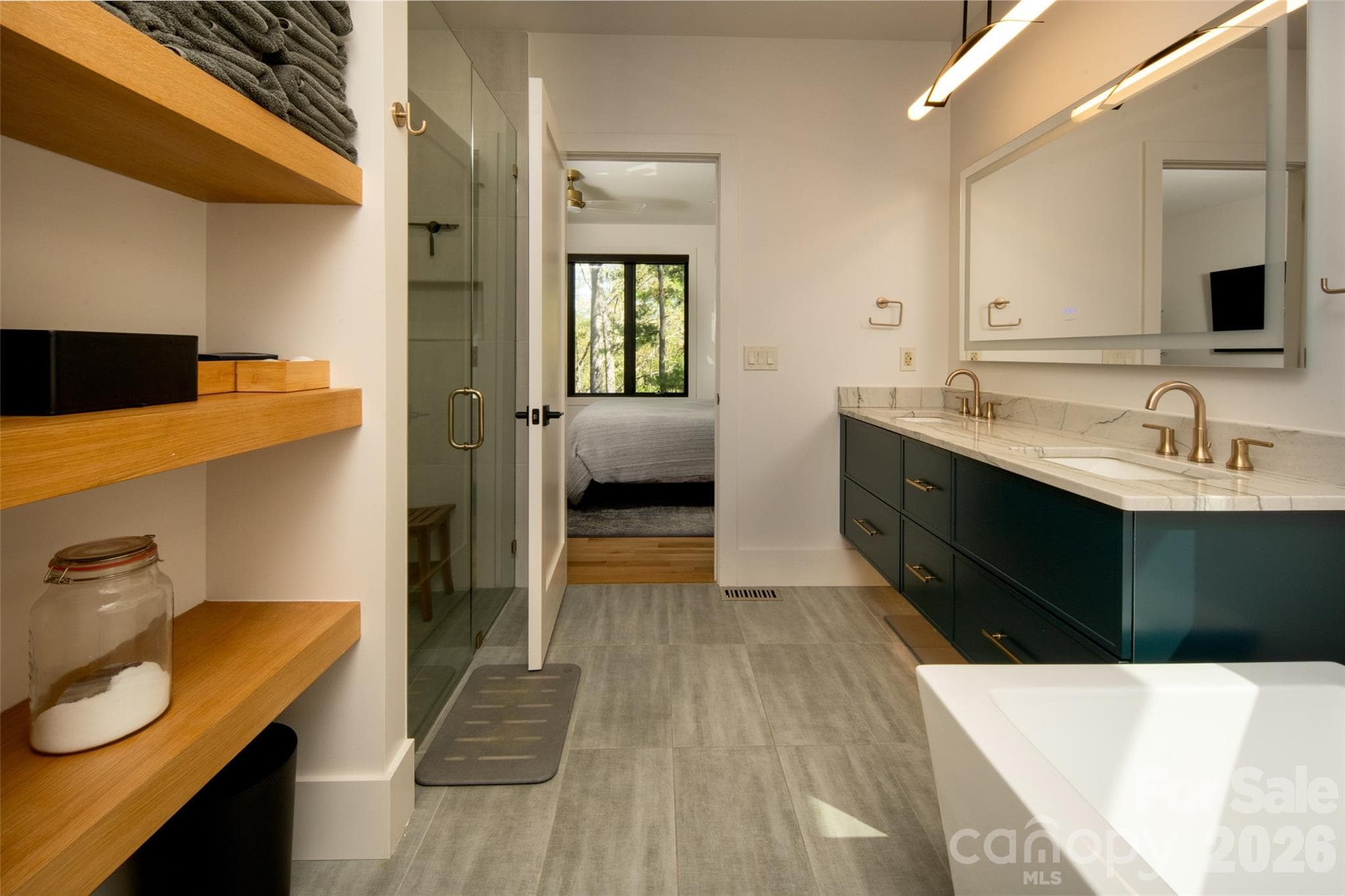 Another view of the ensuite bath. Custom floating wood shelves on left and double vanity with LED mirror on right. - Asheville