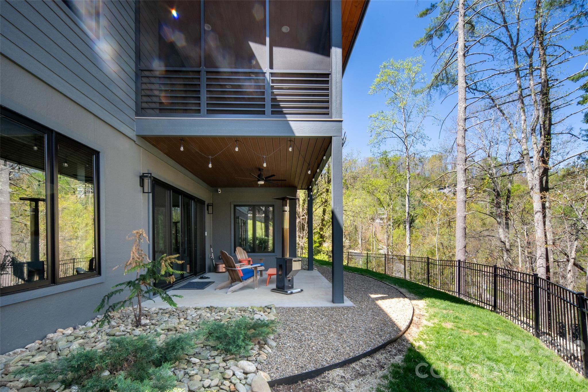 View of lower level covered porch and beautiful outdoor space. - Asheville