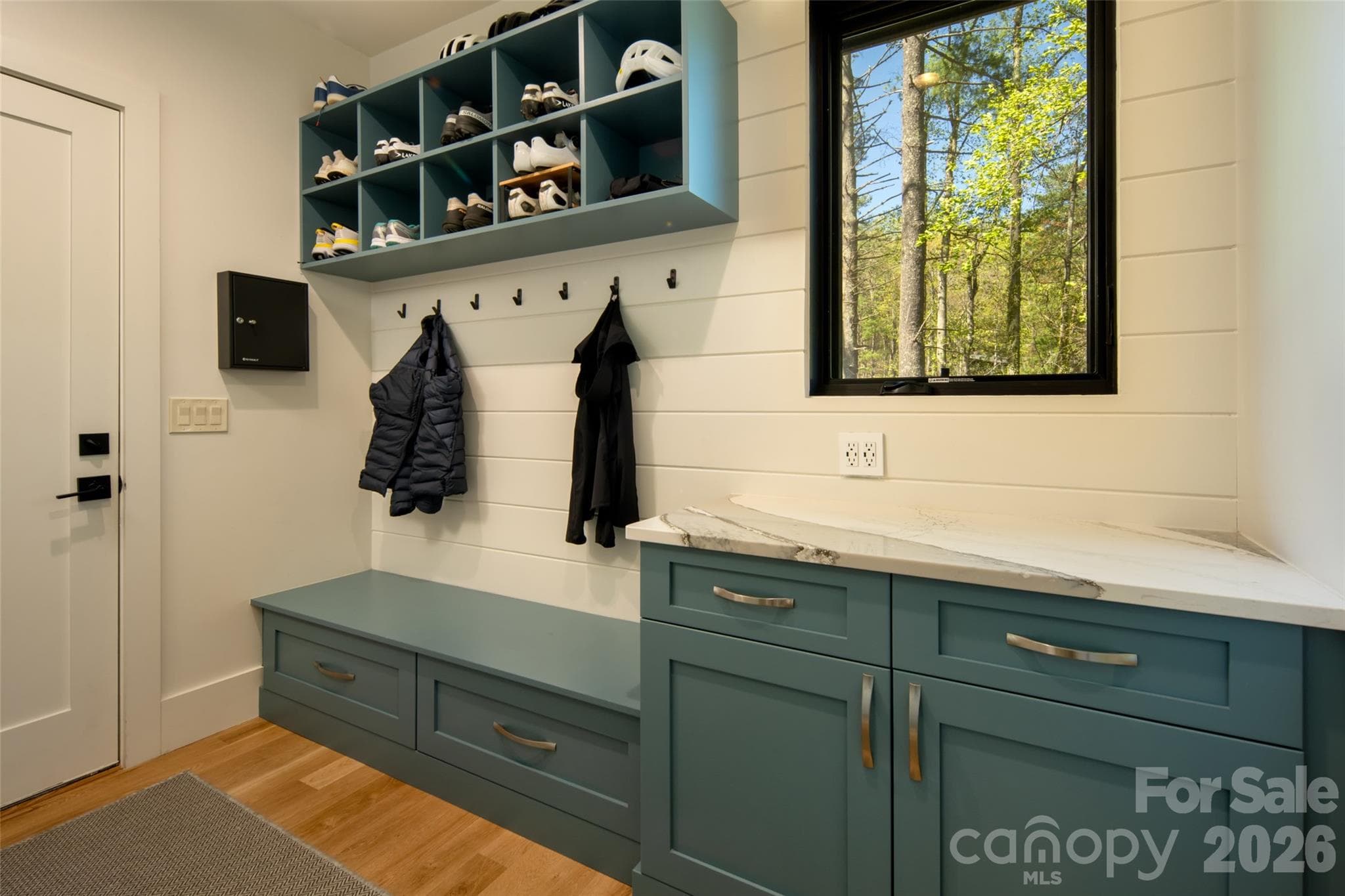 Drop zone as you enter in from attached two-car garage (garage features newly installed Newage Bold Series cabinetry), complete with custom cabinetry, shelving and nickel gap walls. - Asheville