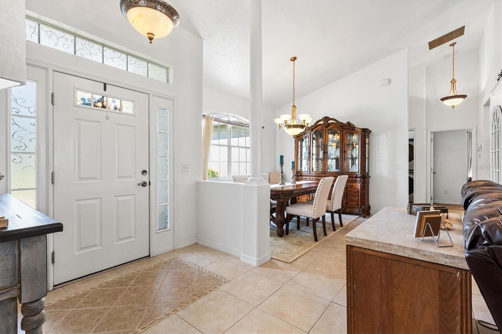 Open foyer with vaulted ceilings, gazing out toward the canal and private boat dock, creating a bright and inviting waterfront atmosphere. - 12107 EAGLE POINT CT, LEESBURG