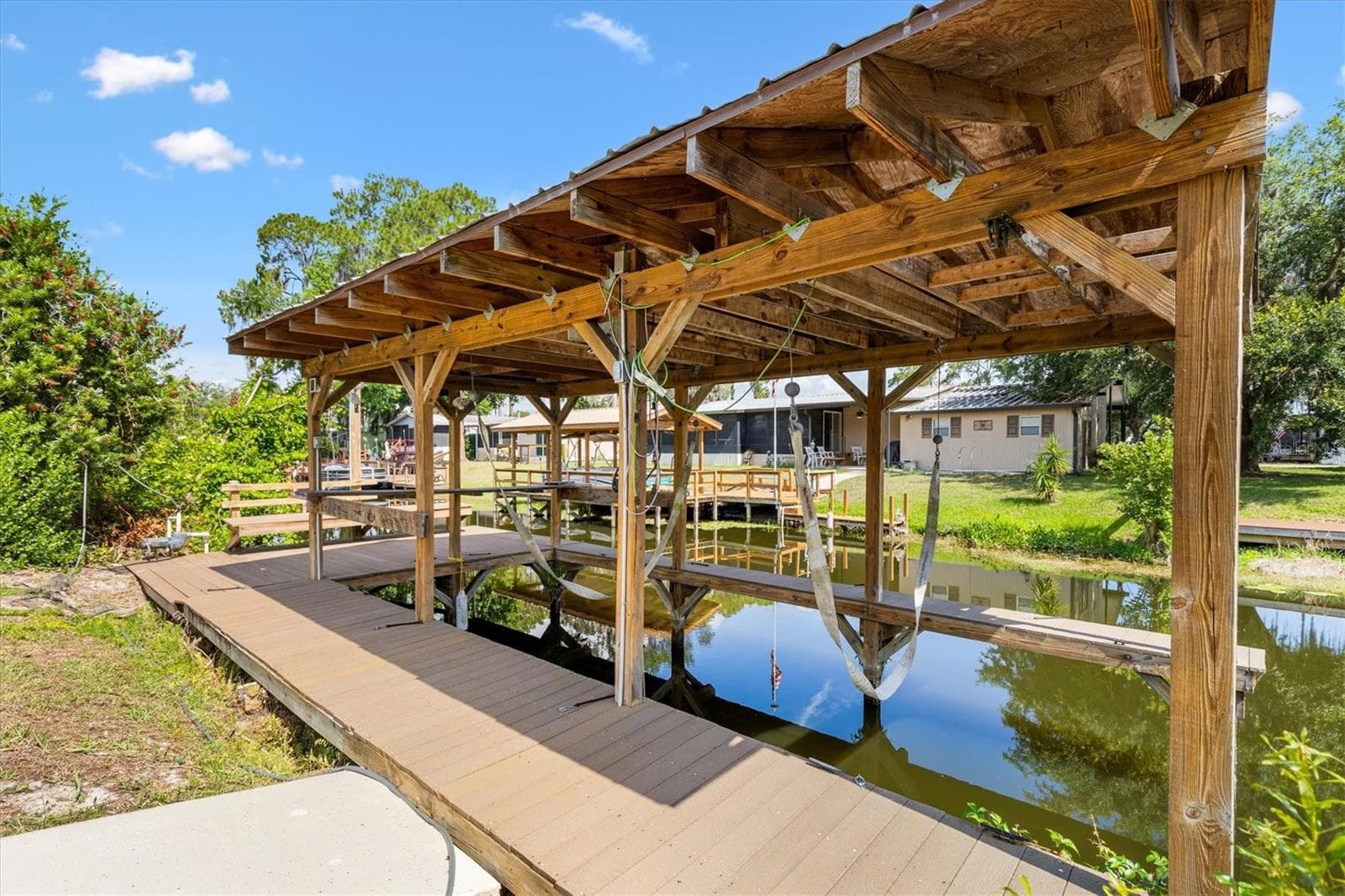 Covered boat dock featuring electric service and durable composite decking, perfect for enjoying the waterfront lifestyle with low-maintenance convenience. - 12107 EAGLE POINT CT, LEESBURG