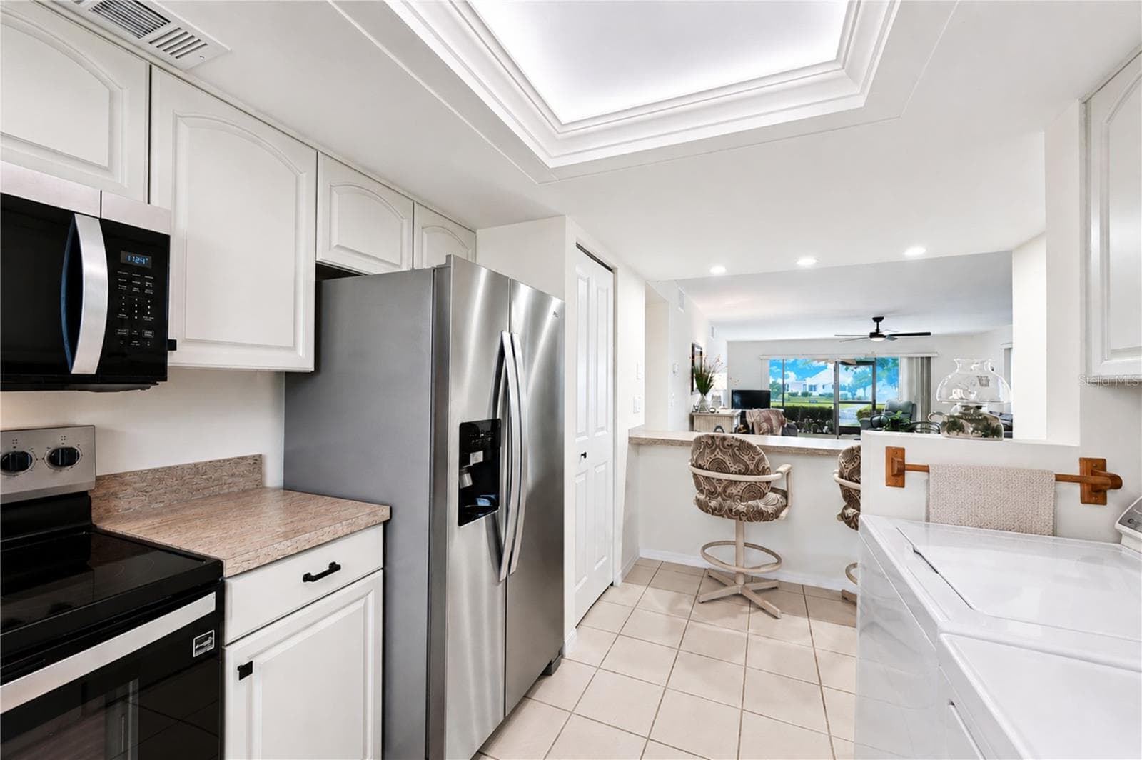 View from kitchen extends through the entertaining areas to the outdoors - 4853 INDEPENDENCE DR, BRADENTON