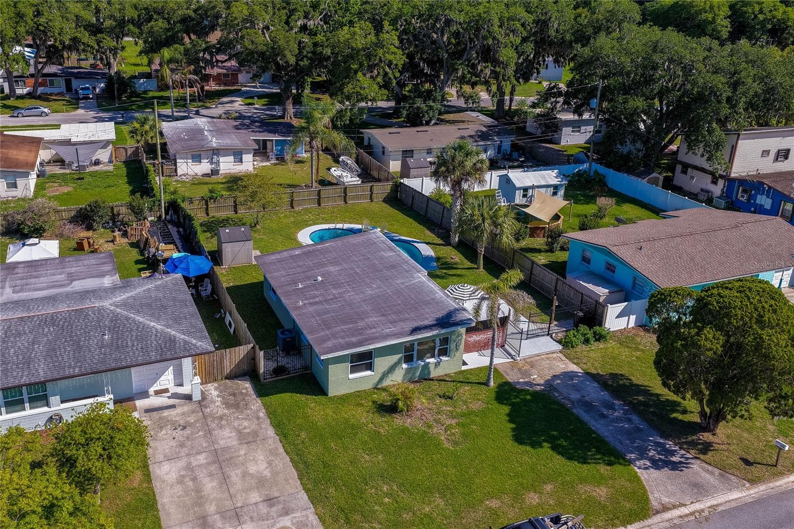 Elevated aerial view showcasing the home’s layout within the neighborhood, highlighting the expansive backyard complete with an in-ground swimming pool. - 723 STEELE AVE, SOUTH DAYTONA