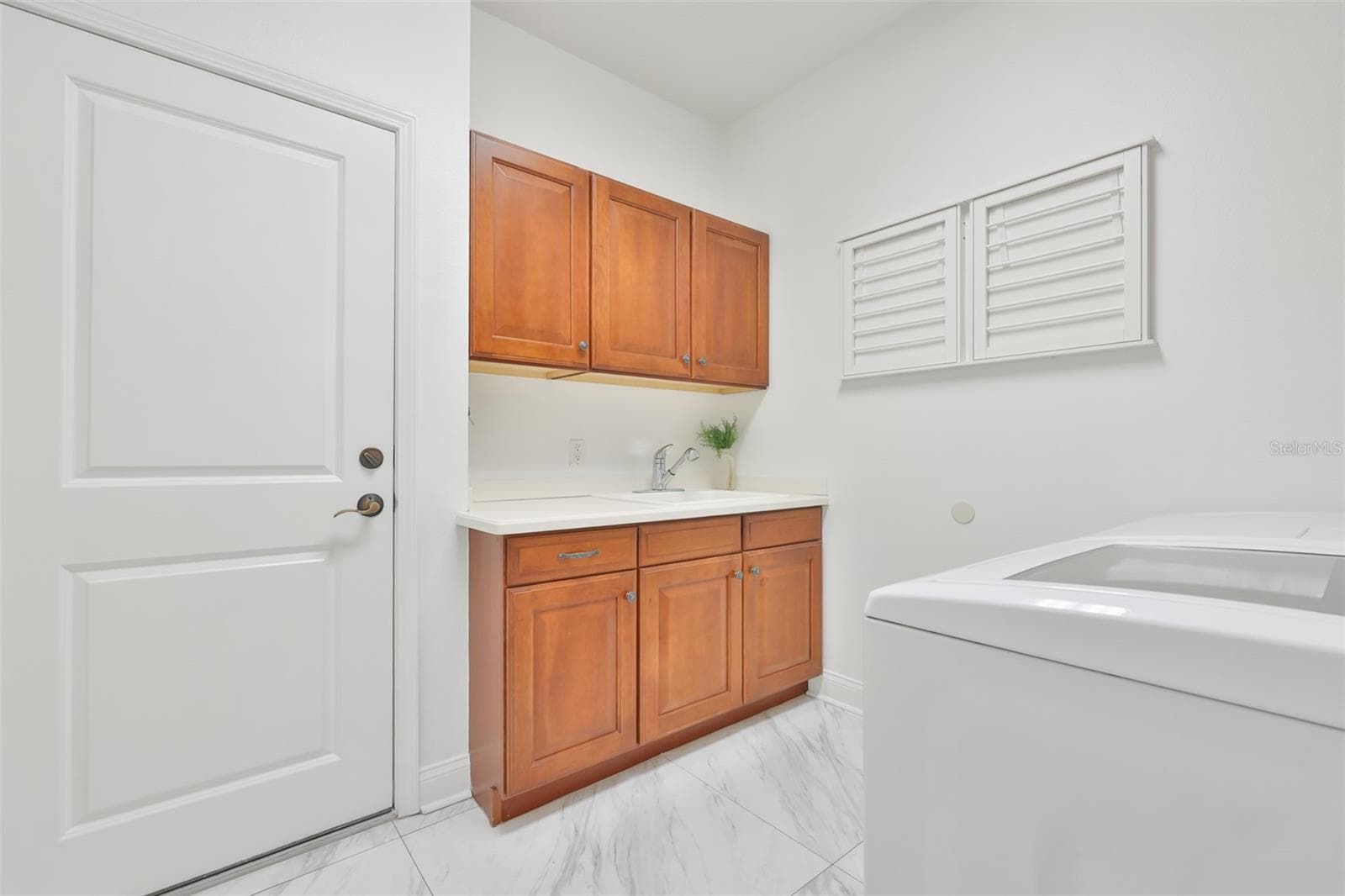 laundry room with cabinets on both sides; retractable drying racks for delicate items - 5318 LOON NEST CT, APOLLO BEACH
