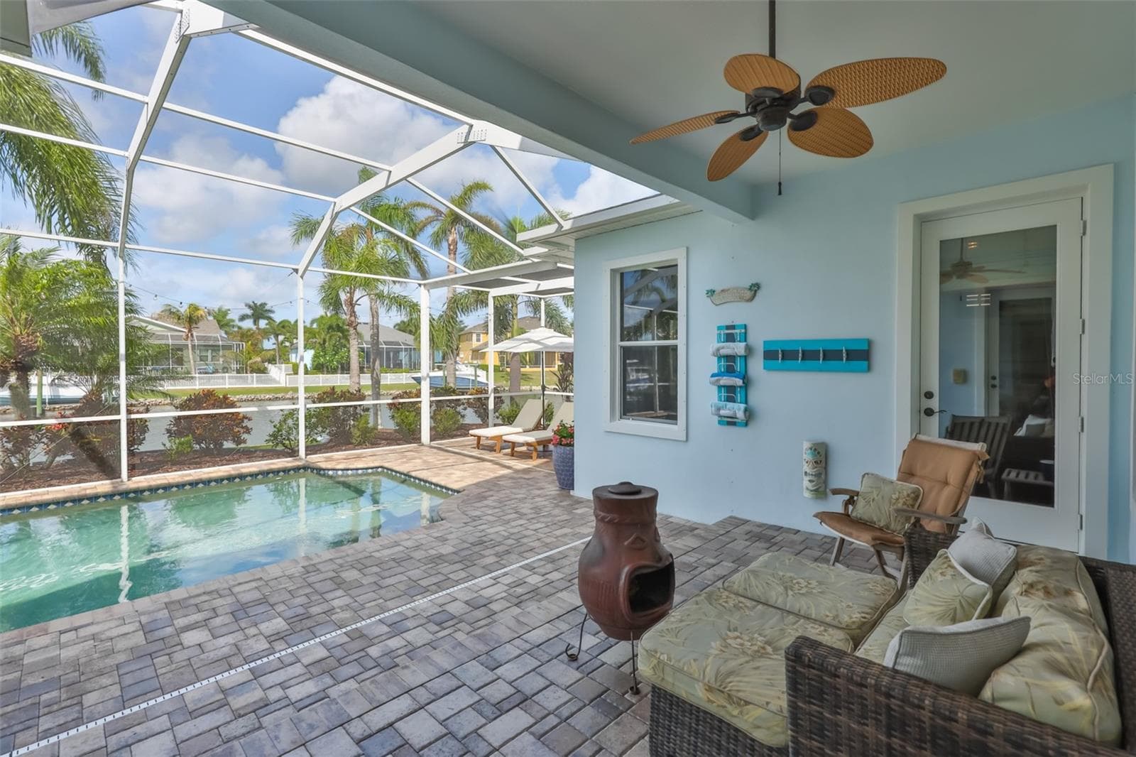 covered lanai with area to lounge and enjoy pool and canal views - 5318 LOON NEST CT, APOLLO BEACH