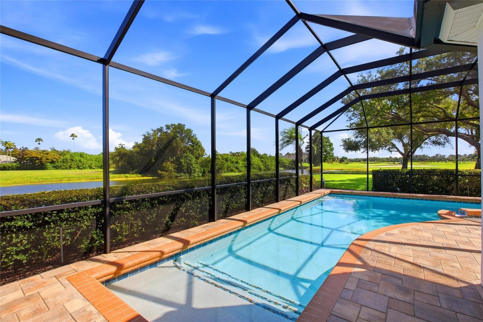 Enjoy resort-style living with a heated pool and spa overlooking the 18th hole, tranquil lake views, and the natural beauty of Misty Creek, where deer are often seen roaming the landscape. - 8417 LONE EAGLE WAY, SARASOTA
