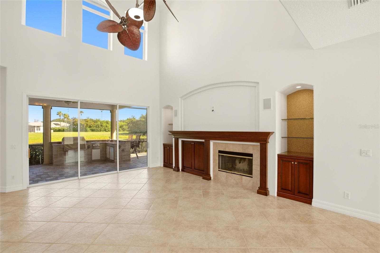 The family room features soaring cathedral ceilings, a fireplace with mantel, and sliding glass doors opening to the lanai, while flowing seamlessly into the kitchen for comfortable everyday living and entertaining. - 8417 LONE EAGLE WAY, SARASOTA