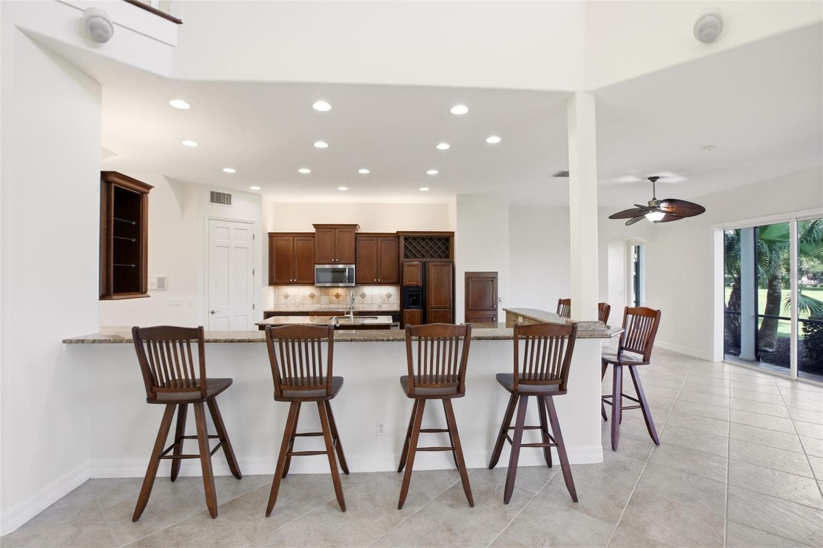 The kitchen offers an extensive breakfast bar and a comfortable casual dining area, along with generous counter space, dual sinks, double ovens, abundant cabinetry, and a spacious walk-in pantry. - 8417 LONE EAGLE WAY, SARASOTA