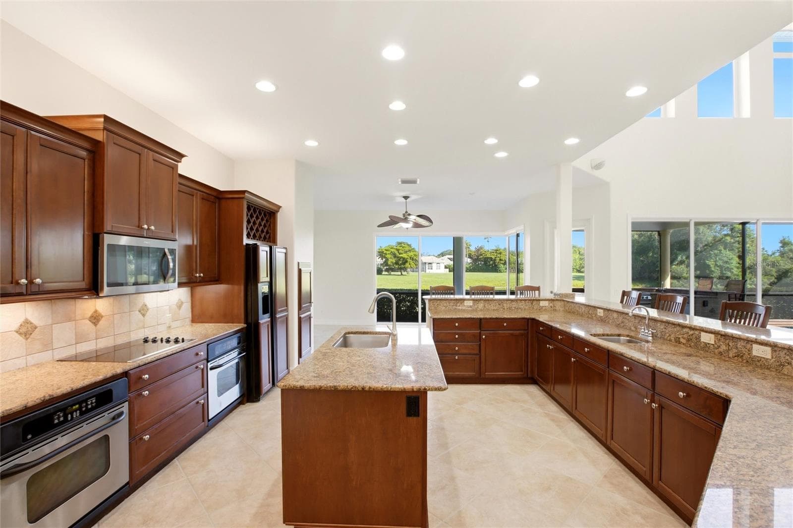 The kitchen offers an extensive breakfast bar and a comfortable casual dining area, along with generous counter space, dual sinks, double ovens, abundant cabinetry, and a spacious walk-in pantry. - 8417 LONE EAGLE WAY, SARASOTA