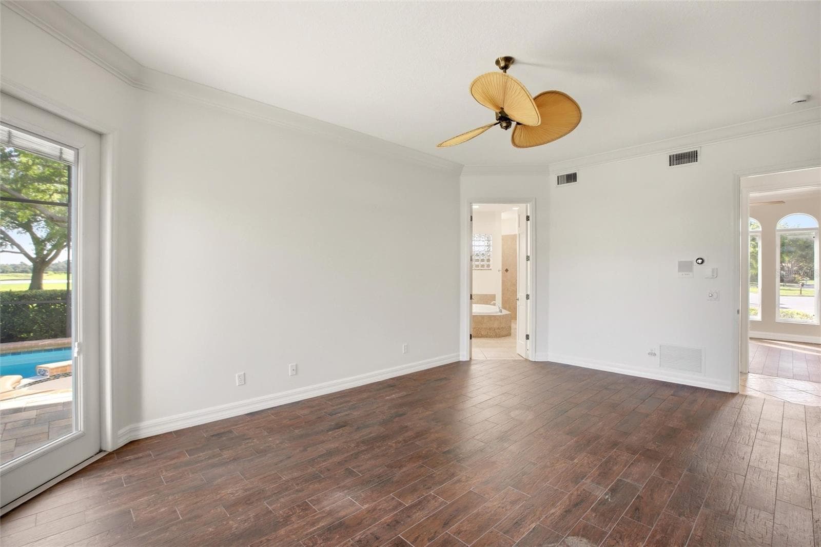The first-floor primary suite features direct access to the lanai and showcases peaceful views of the lake and pool. - 8417 LONE EAGLE WAY, SARASOTA